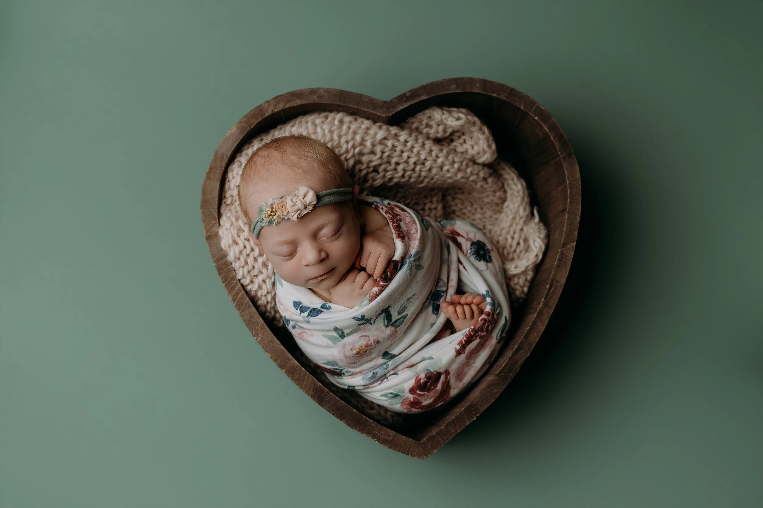 newborn-baby-girl-sleeping-wooden-heart-bowl-prop.jpg