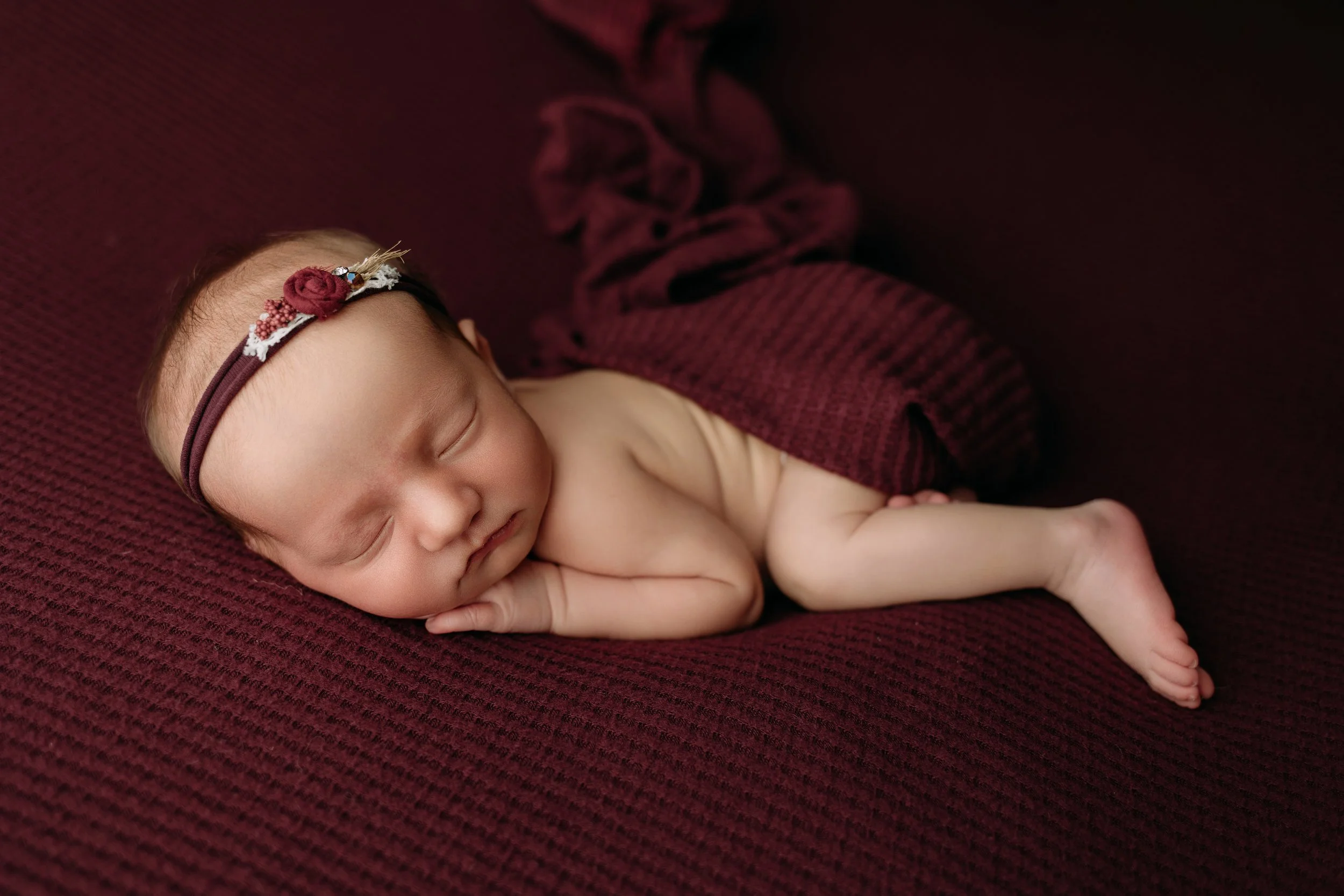 newborn-baby-girl-sleeping-on-red-blanket.jpg