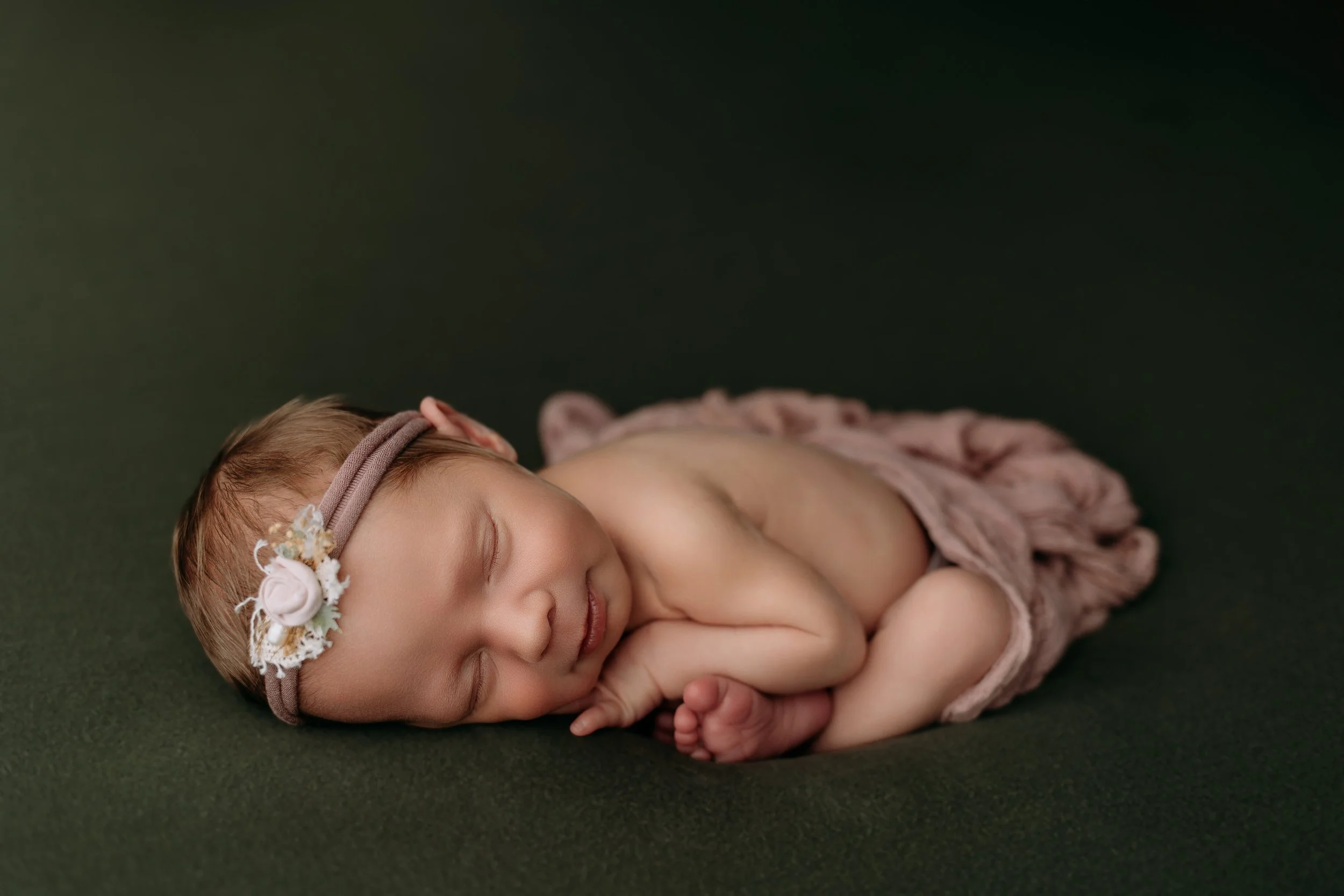 newborn-baby-girl-photoshoot-sleeping-on-olive-green-blanket.jpg