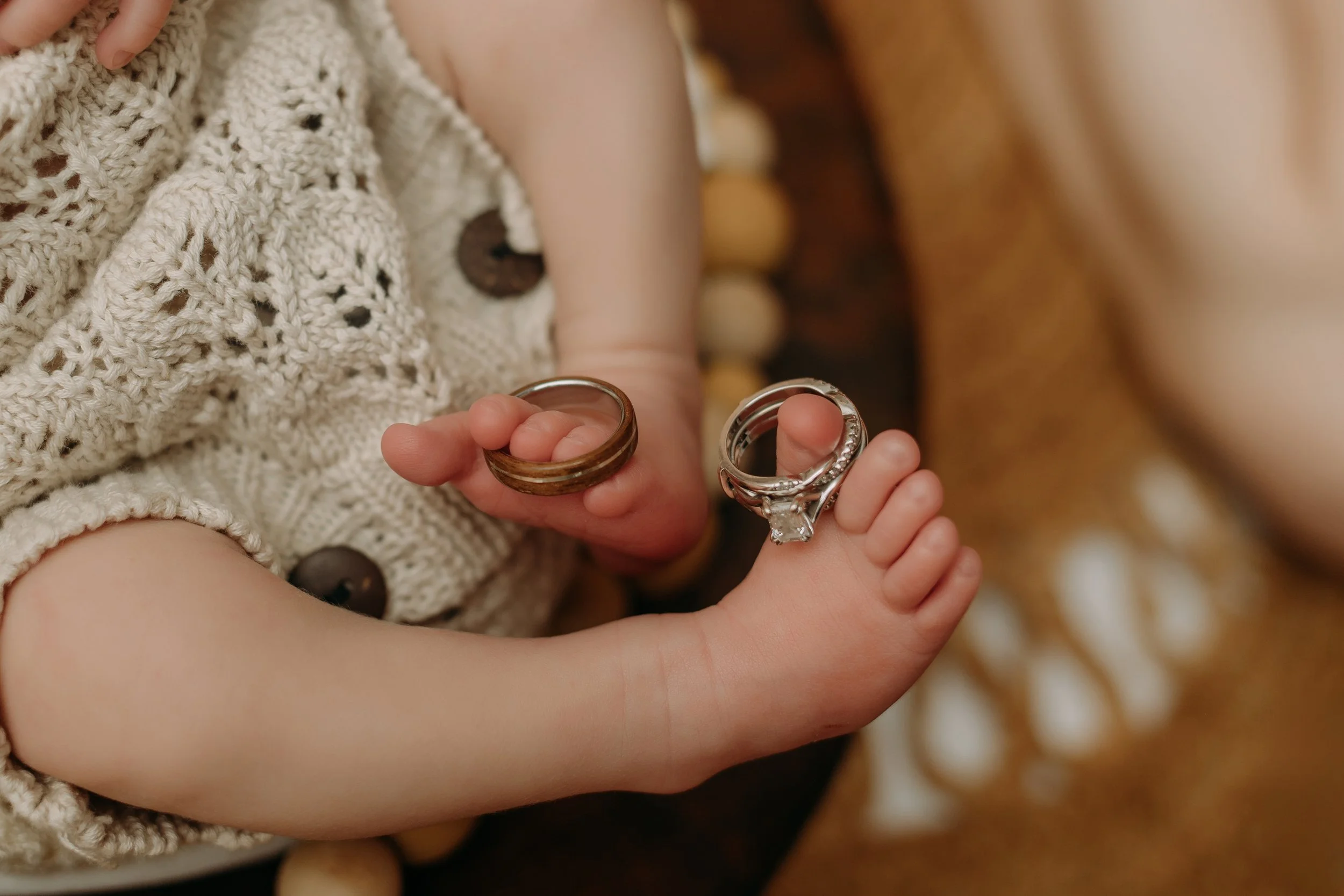 newborn-baby-hands-holding-wedding-rings-detail.jpg