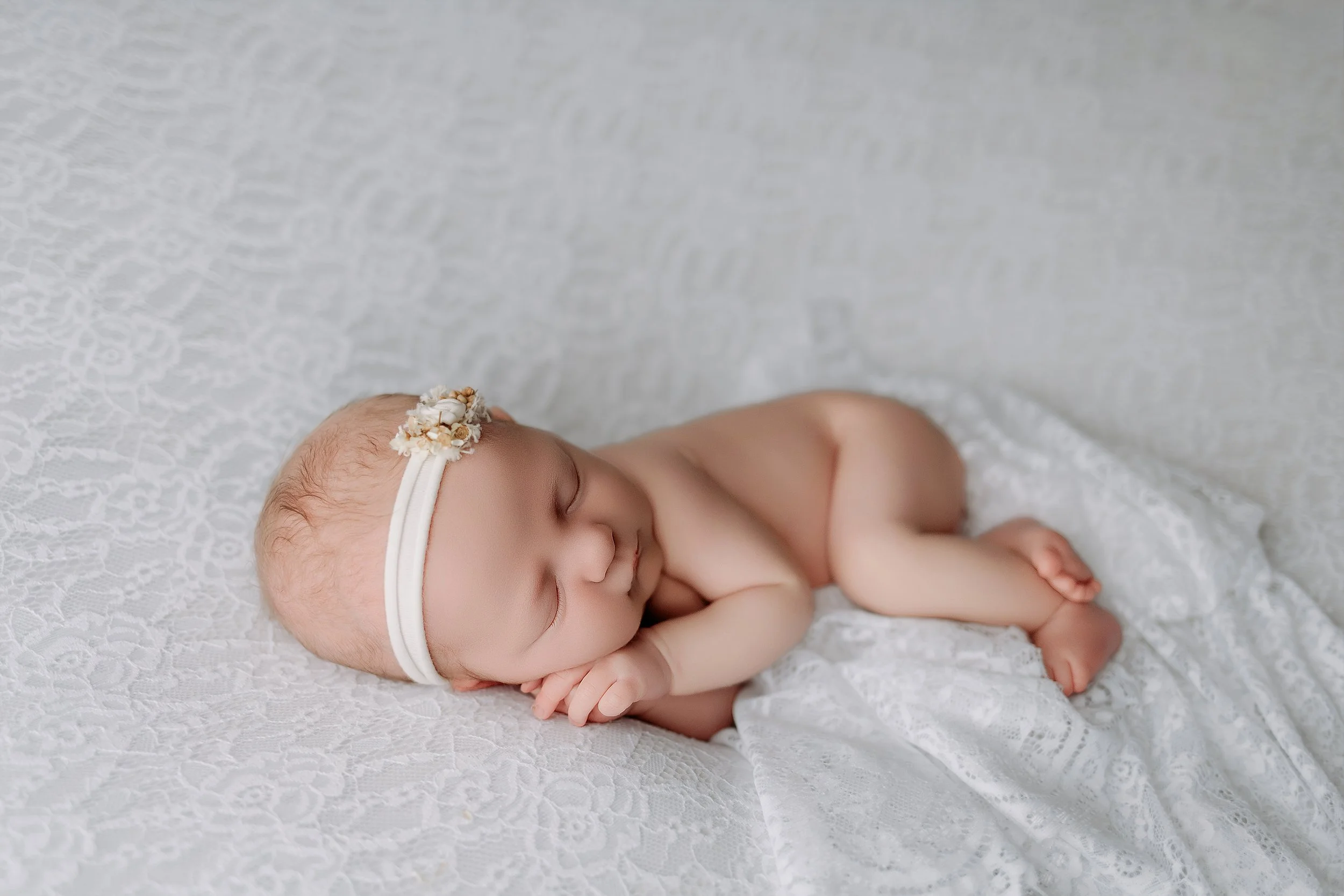 newborn-girl-photoshoot-sleeping-on-white-lace.jpg