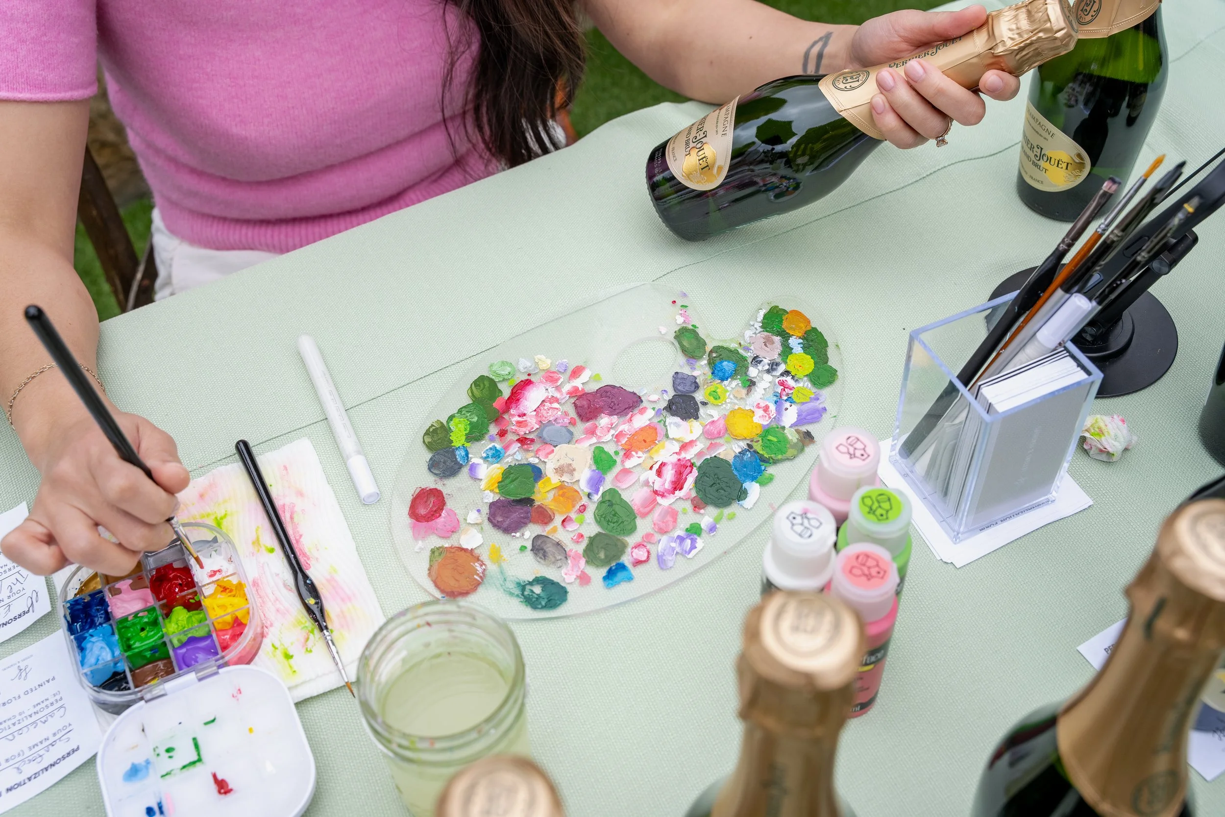 Live floral painting on champagne bottles for guests