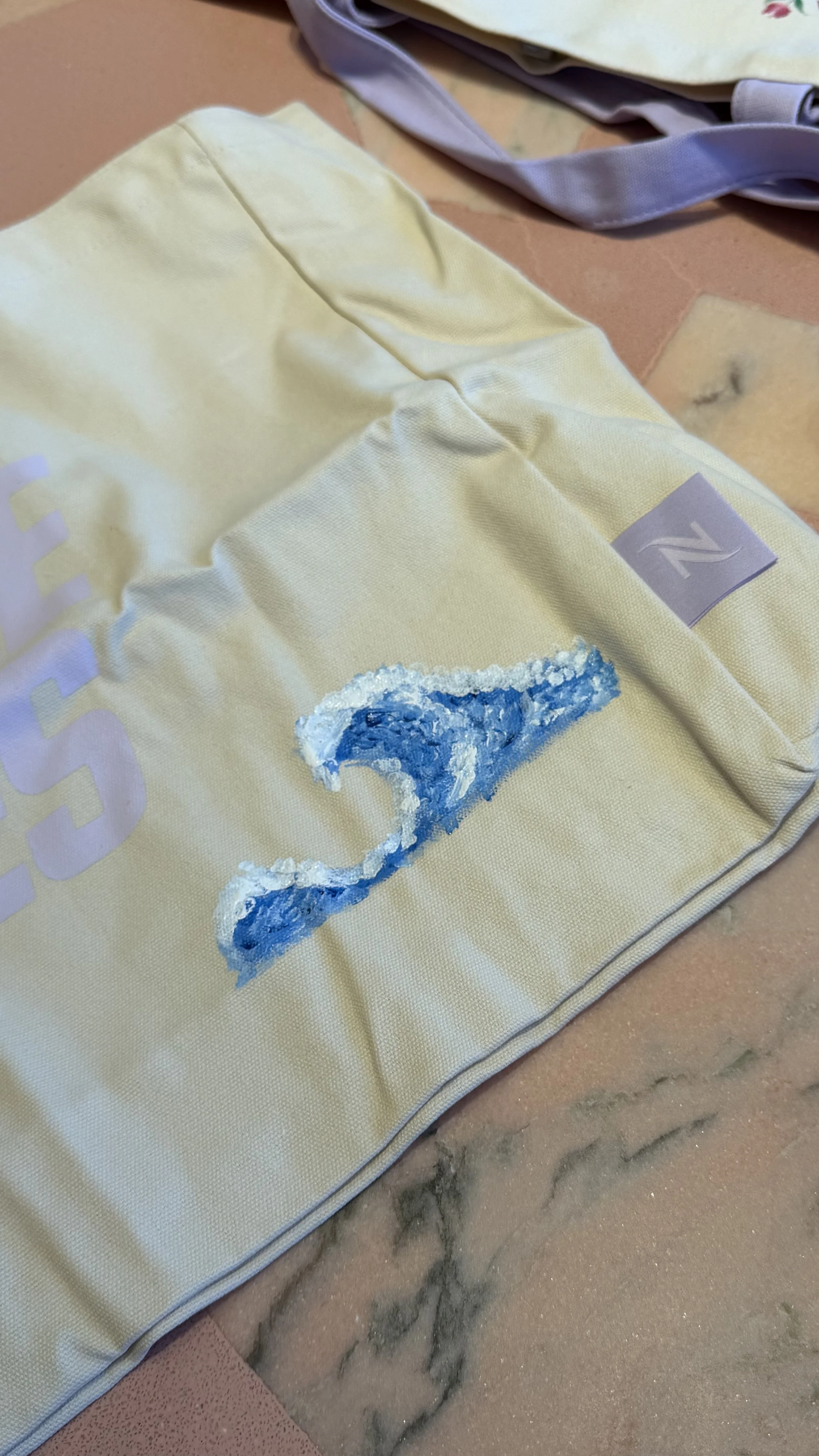 Hand painted surf wave on tote bag for a customer at Nespresso Fashion Island brand retail activation in Orange County, CA