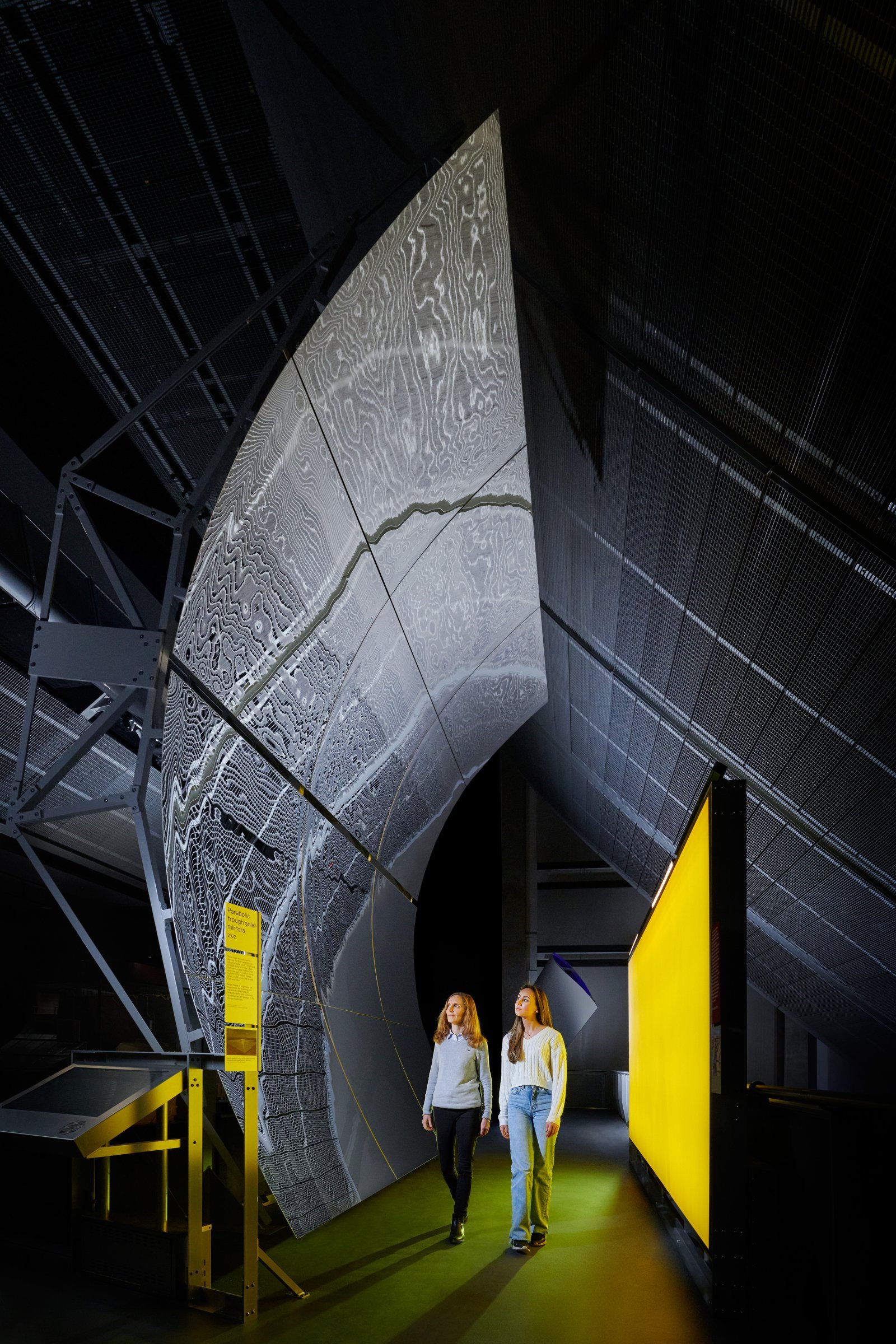 03_Visitors with a parabolic trough solar mirrors in Energy Revolution The Adani Green Energy Gallery at the Science Museum © Science Museum Group.jpg