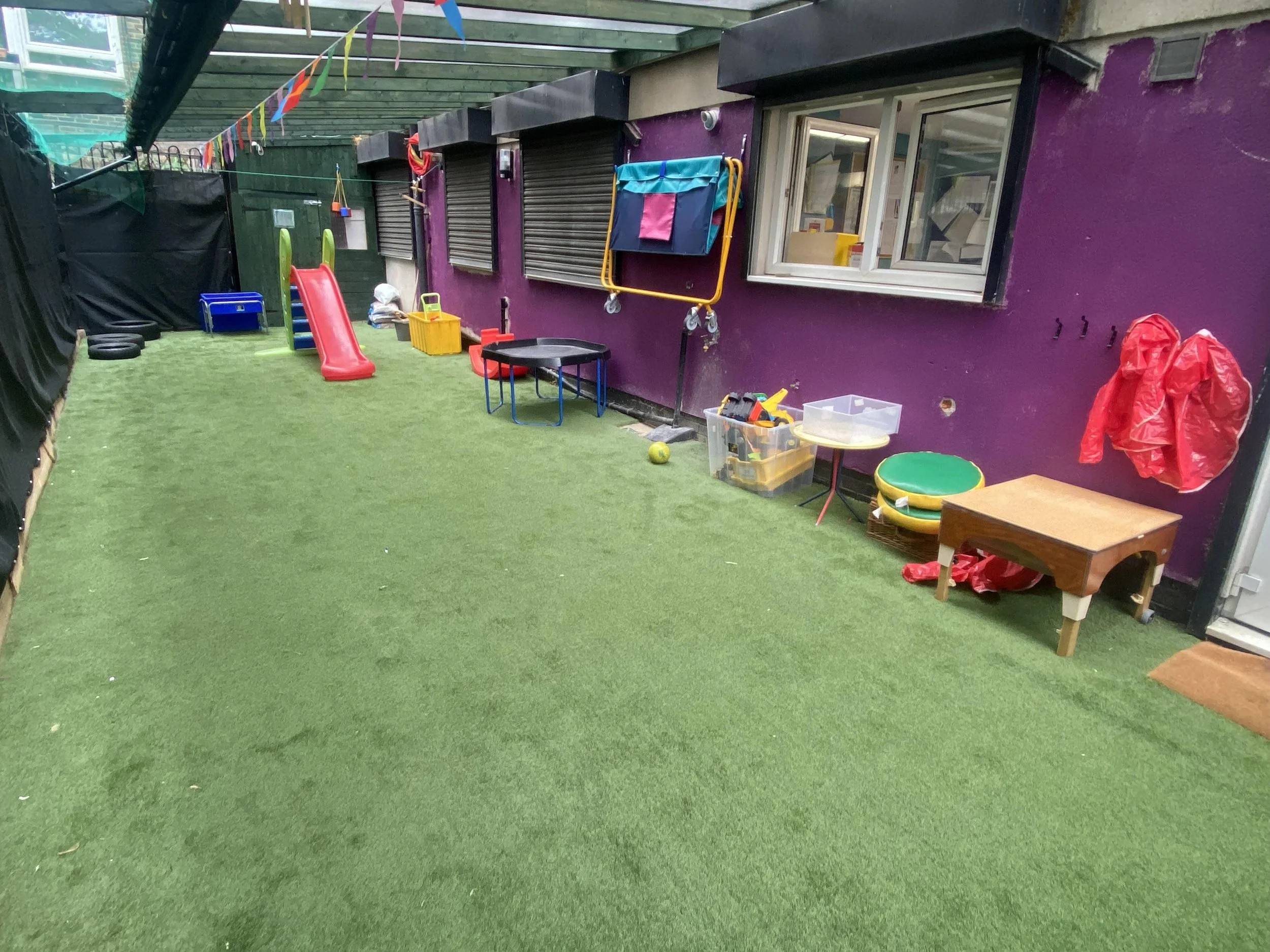 rear garden with canopy and artificial grass at Whitechapel nursery for year-round outdoor learning