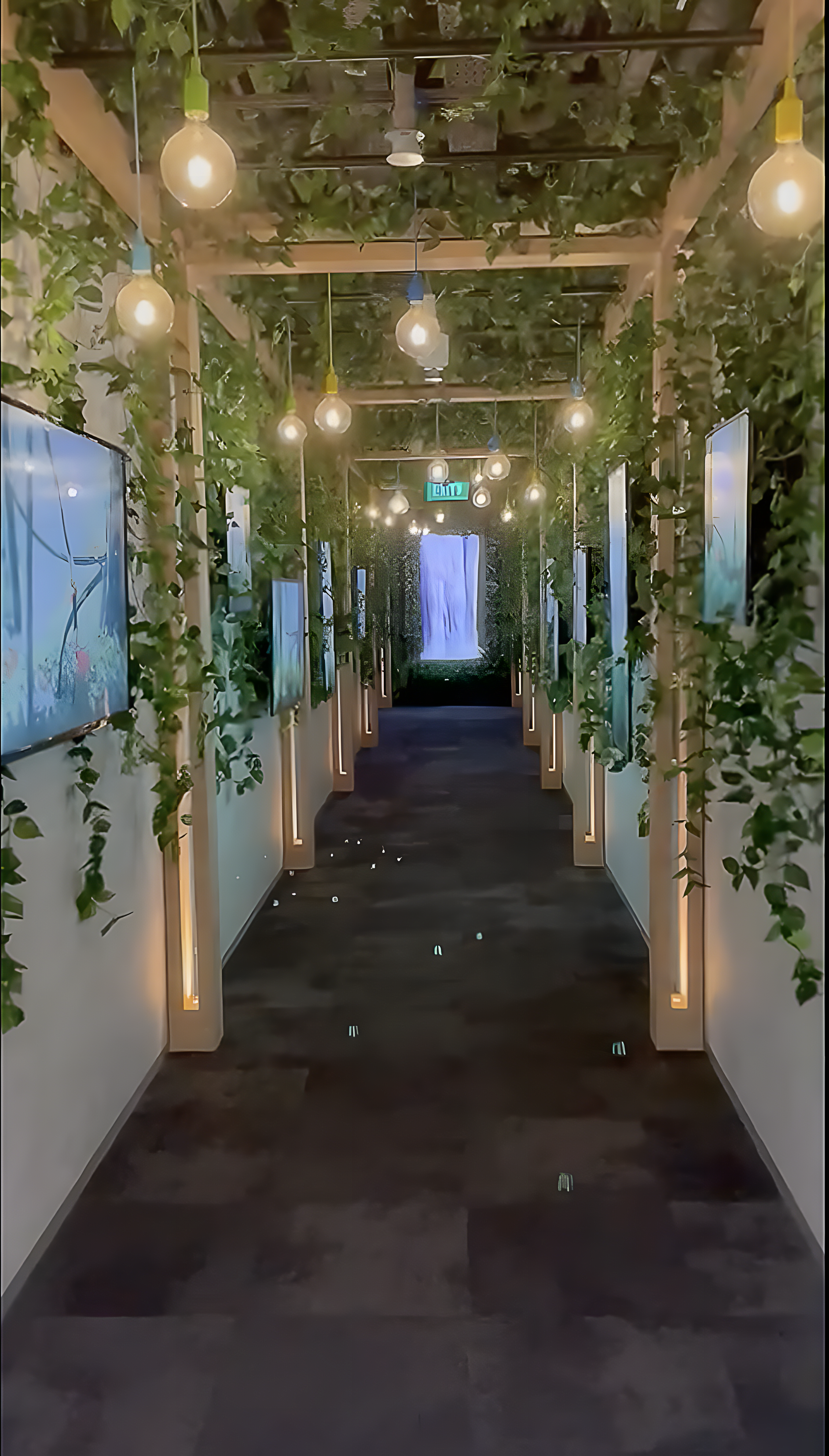 Greenhouse style ideation hub corridor in Singapore featuring digital displays, integrated lighting and biophilic design with overhead planting.