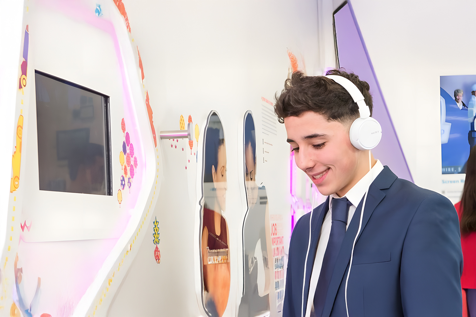 Visitor engaging with interactive wall content and audio storytelling at the Sky Visitor Centre