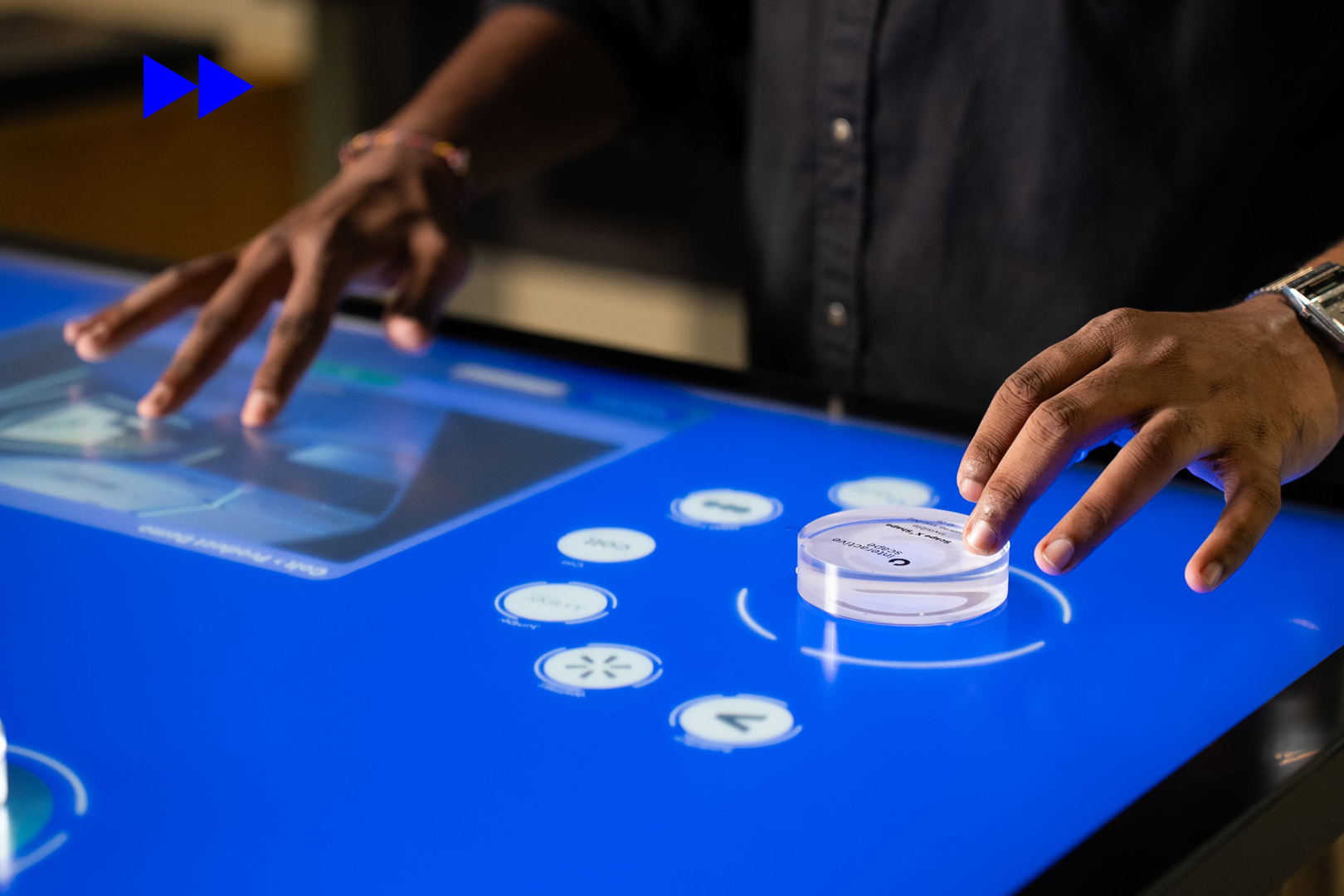 Object Recognition Table interaction in a customer experience centre, showing physical objects triggering digital content on a touchscreen surface.