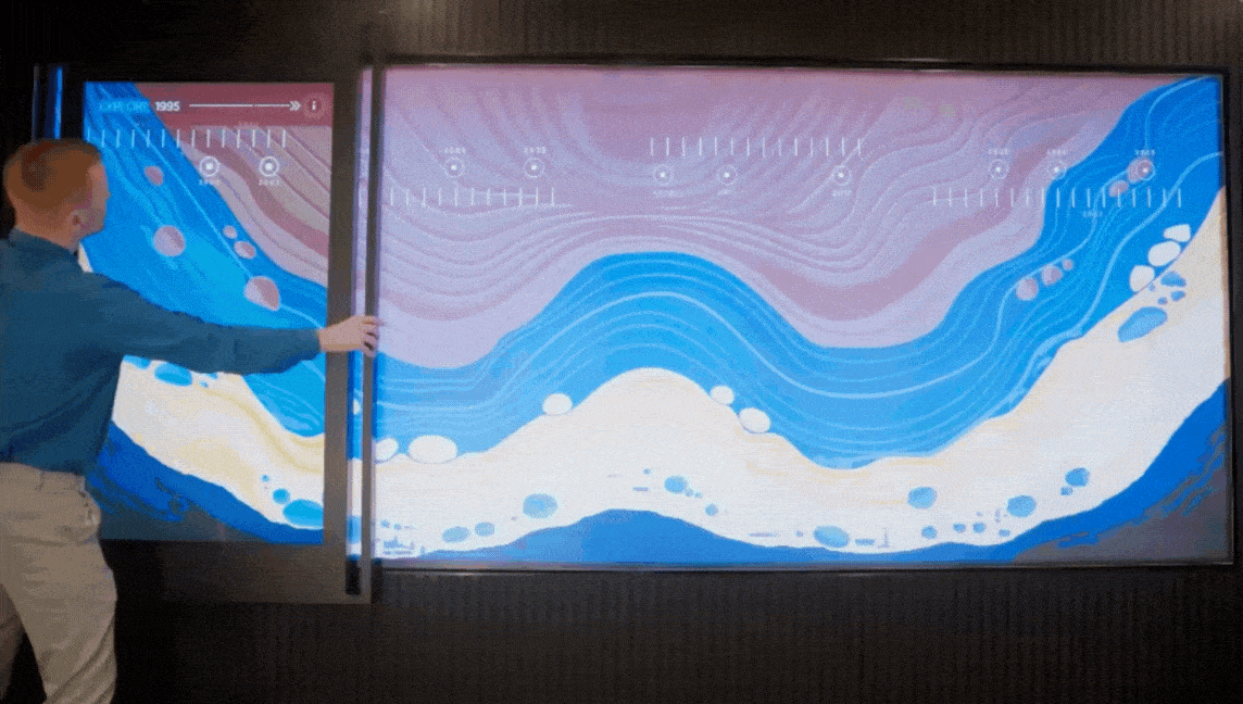 Interactive digital slider wall showing dynamic data visualisation content in a corporate experience centre designed and delivered by DVSI.