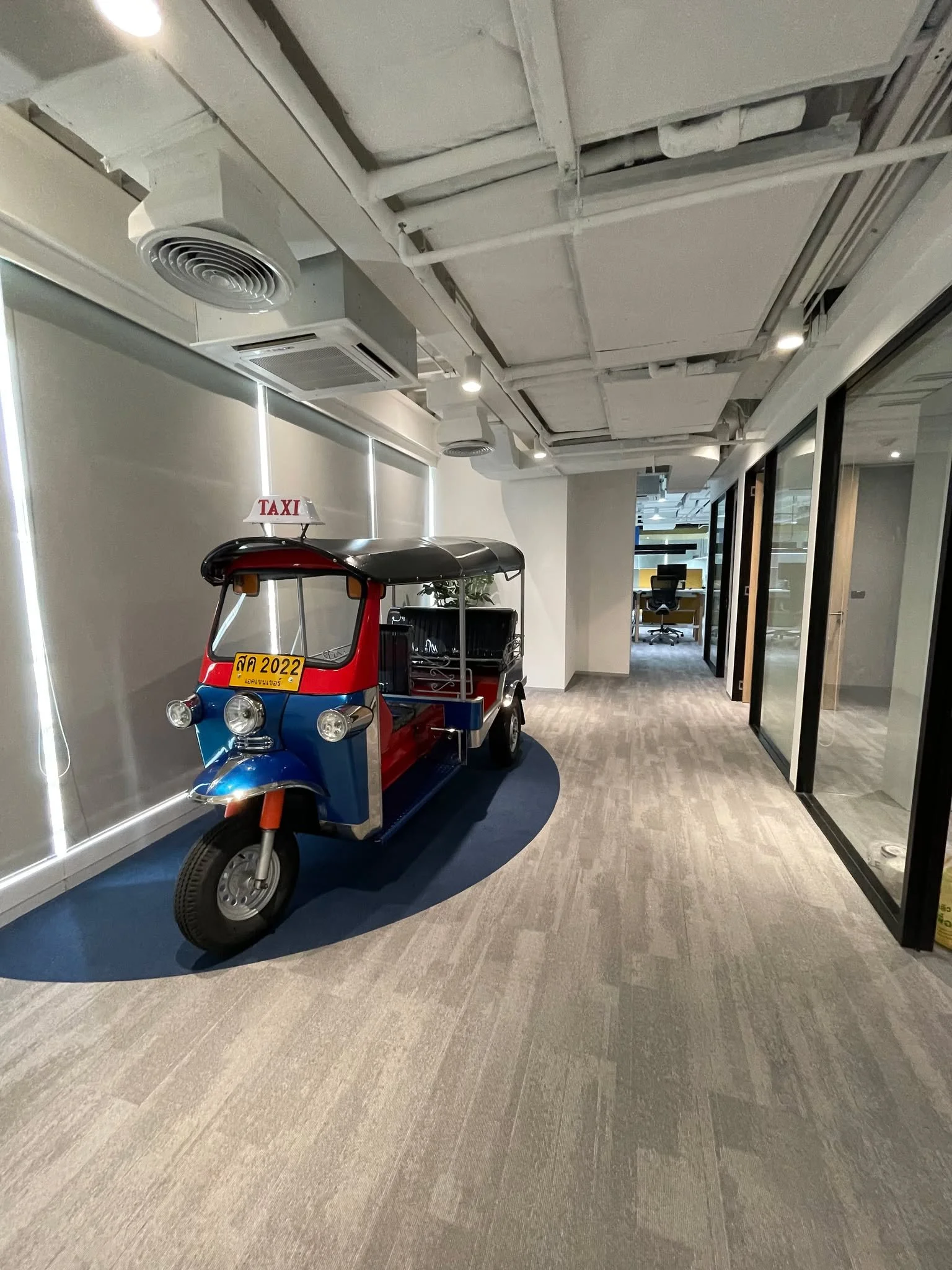 Colourful tuk tuk feature displayed in a modern office corridor within a BPO production floor in Thailand.