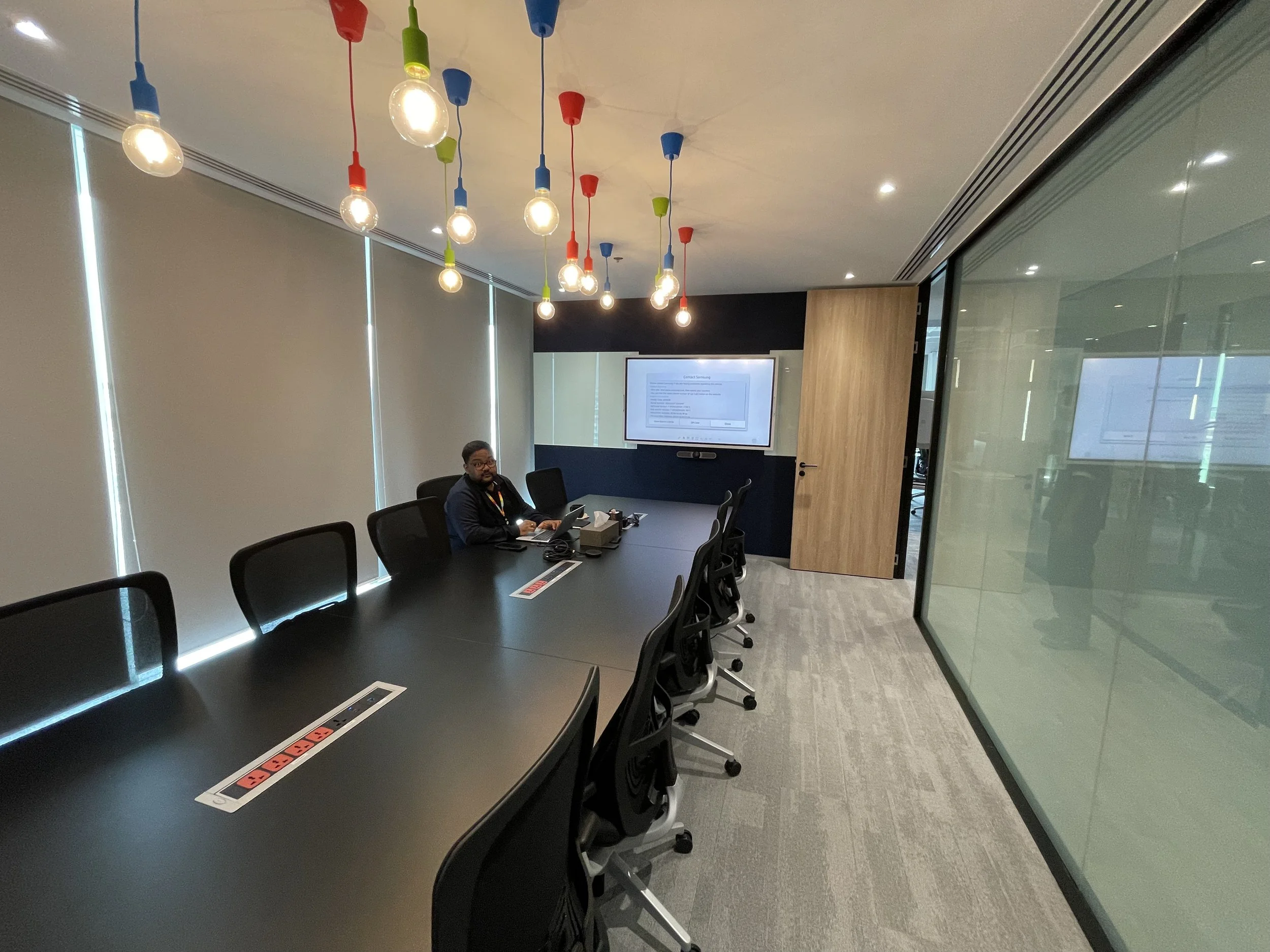 Large meeting room on a BPO production floor in Thailand with integrated audiovisual system, conference table, and decorative lighting