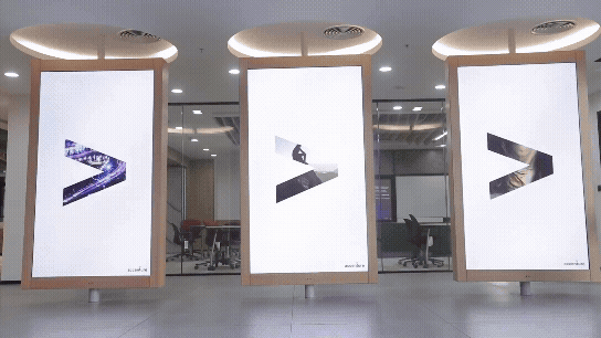 Kinetic digital display with three rotating pillars showcasing dynamic content in a corporate lobby designed by DVSI.