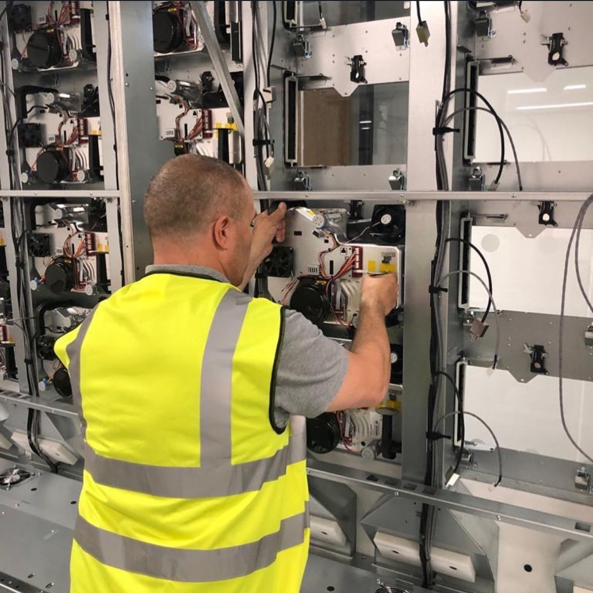 Technician installing and configuring LED display modules during the deployment of a large scale digital video wall system