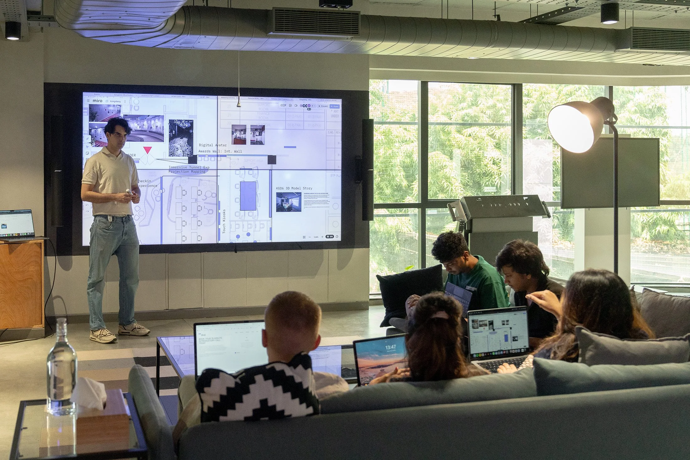 DVSI team running a collaborative design workshop using a large digital display to review layouts, concepts, and experience centre planning during a consulting session