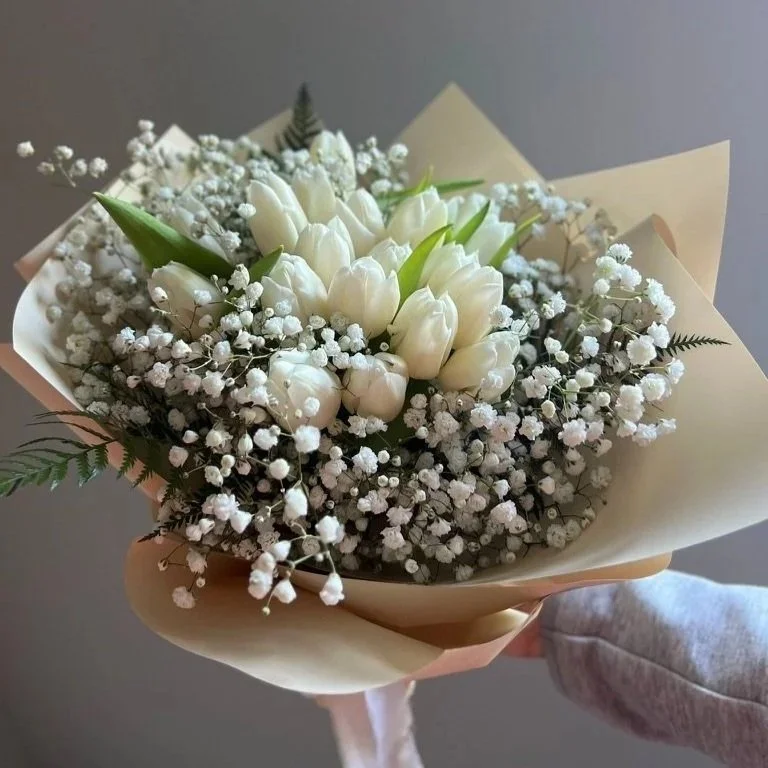 Luxury hand-wrapped tulip bouquet with fresh premium tulips, accented with delicate fillers and finished in elegant pastel wrapping.