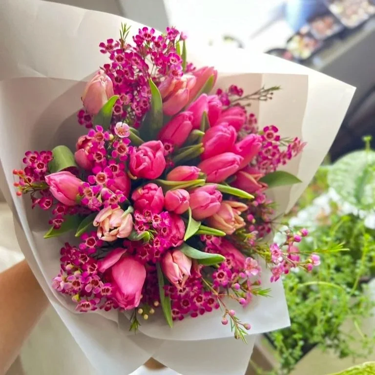 Luxury hand-wrapped tulip bouquet with fresh premium tulips, accented with delicate fillers and finished in elegant pastel wrapping.