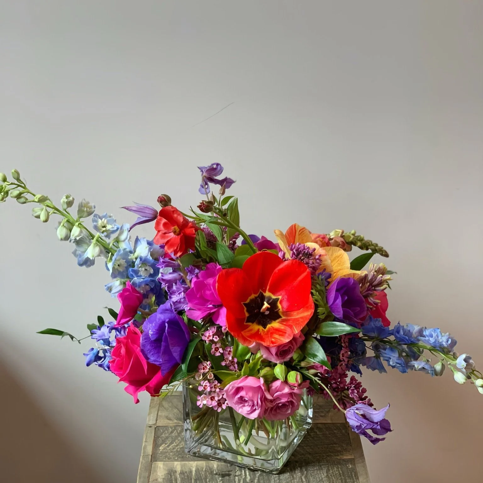 Gemstone Cascade flower arrangement at Meadow Edge Blooms, Columbia SC's top florist, featuring a vibrant palette of orange, red, purple, blue, and green for dynamic, eye-catching floral displays.