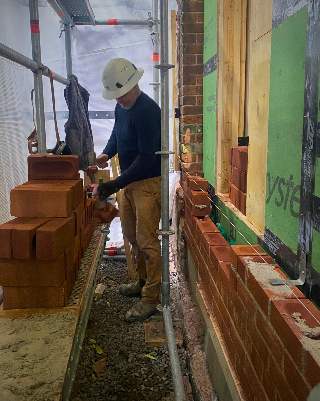 Johnson Playfair mason Brent working on a masonry veneer addition with heritage-match bricks in Toronto.