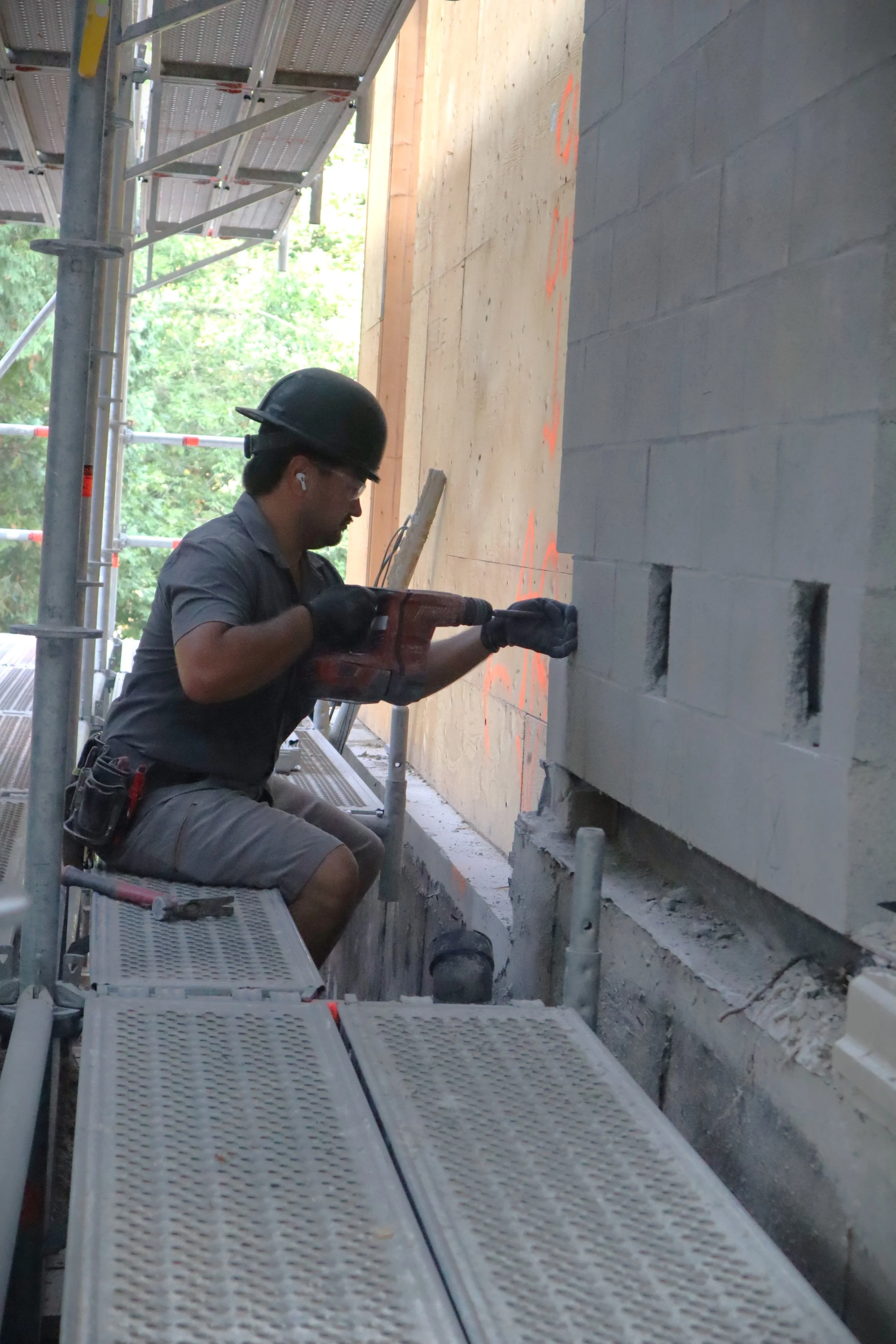Johnson Playfair mason Ken preparing a wall for temporary shoring supports on a renovation in Toronto.