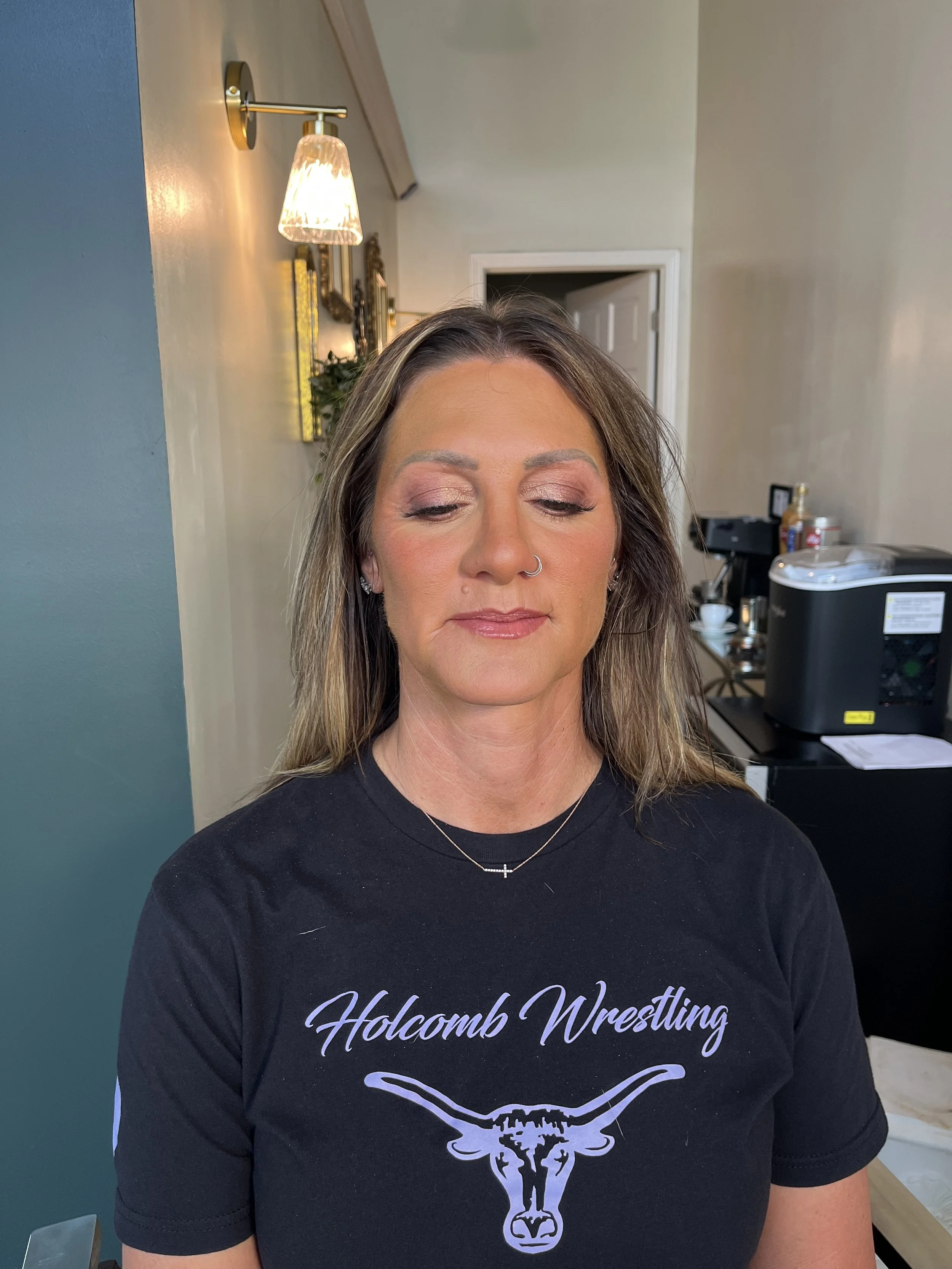 Caucasian woman with brown hair and hazel green eyes wearing a beautiful mauve, purple tone eyeshadow look, with shimmers, that make her eye color stand out. And a full coverage base. Makeup done by Erica K.