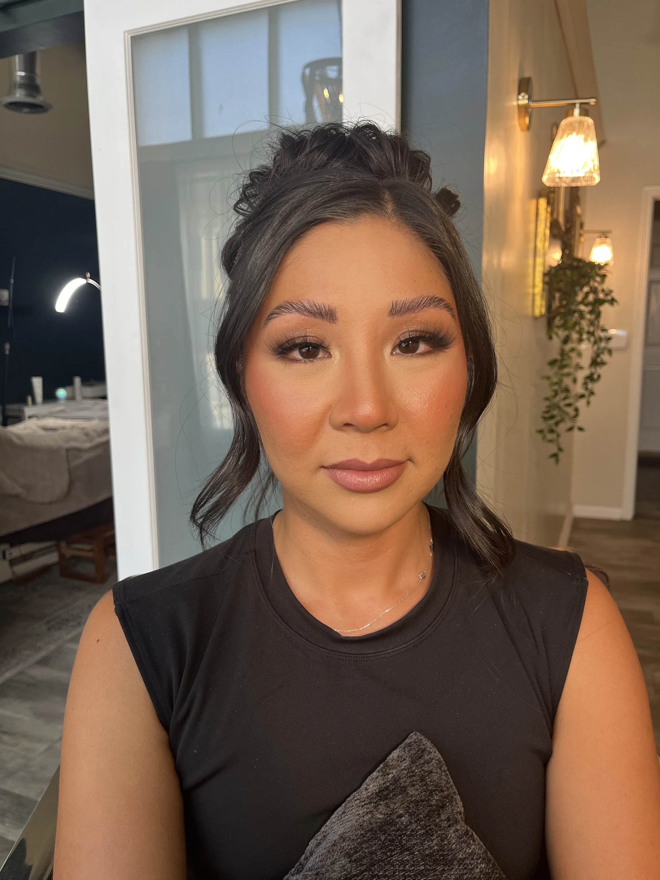 Asian woman who got a sultry makeup look with dark neutral colors and shimmers. Makeup done by Erica