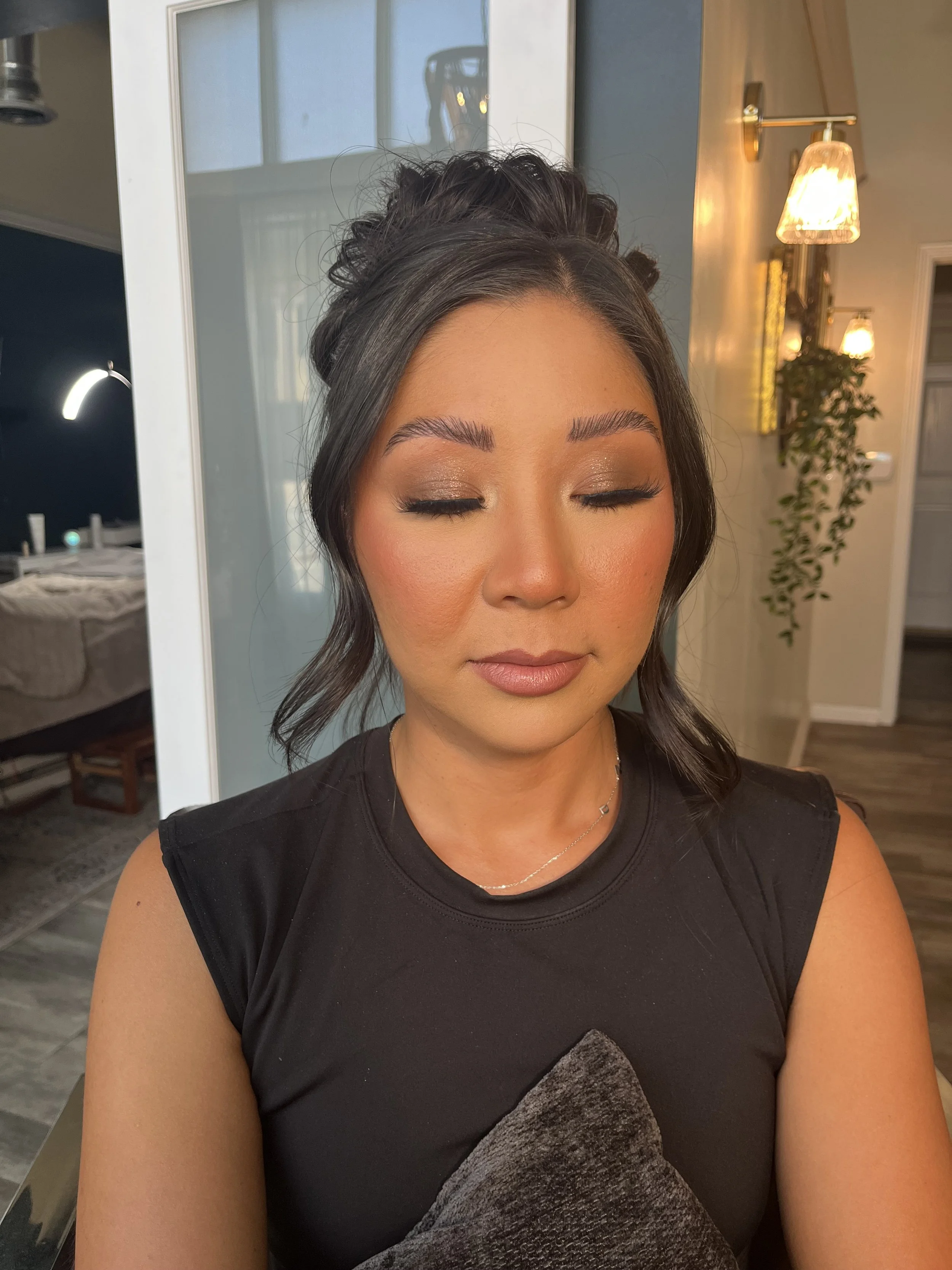 Asian woman who got a sultry makeup look with dark neutral colors and shimmers. Makeup done by Erica