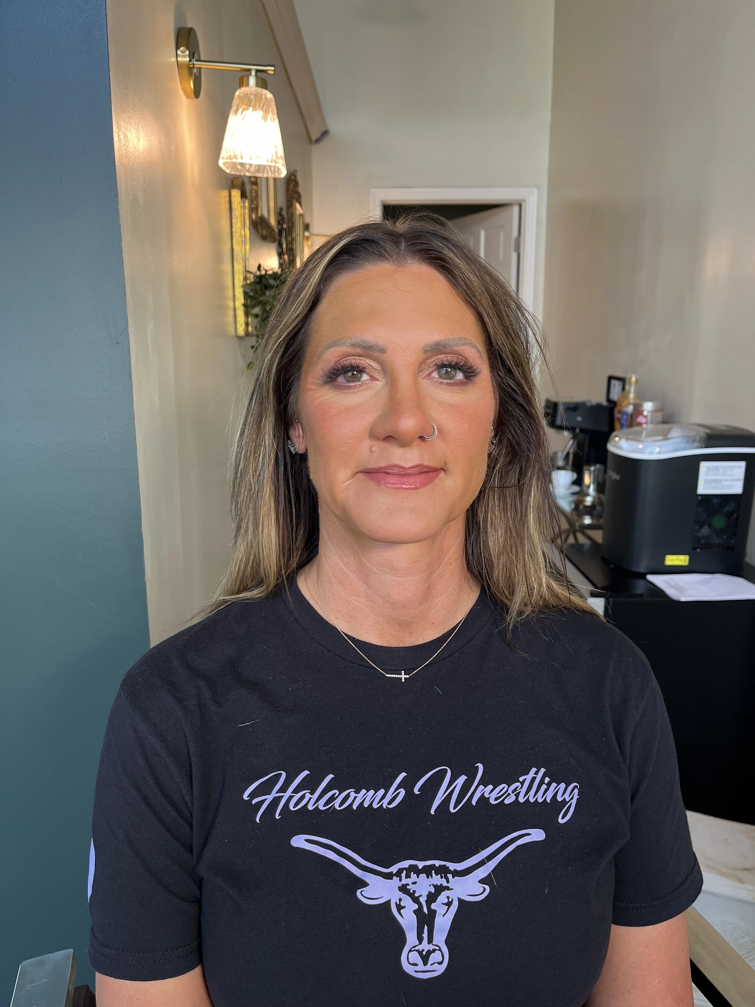 Caucasian woman with brown hair and hazel green eyes wearing a beautiful mauve, purple tone eyeshadow look, with shimmers, that make her eye color stand out. And a full coverage base. Makeup done by Erica K.