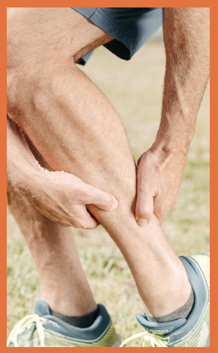 Active man in shorts bending and squeezing pain-point in calf muscle with both hands.