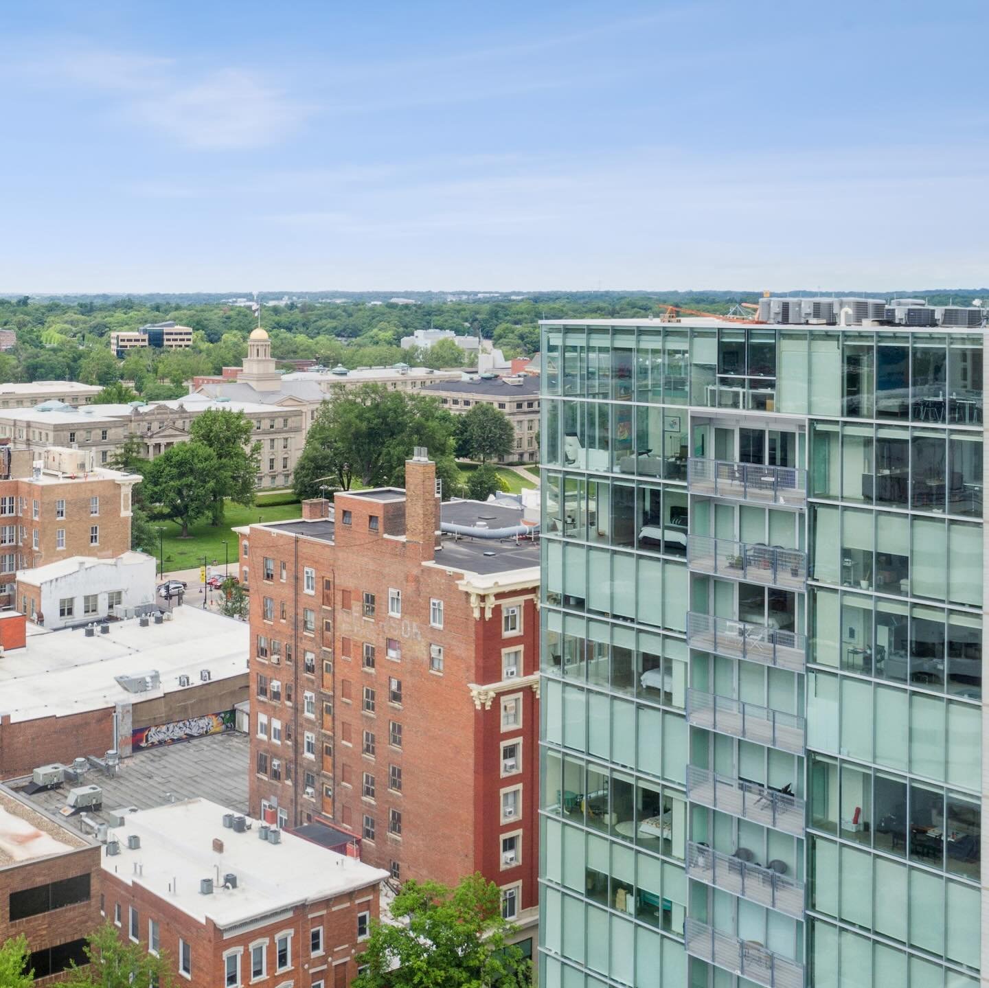 This contemporary 7th-floor condo in Park@201 offers a modern living experience in the center of downtown Iowa City. The main living area features an open floor plan and floor-to-ceiling windows, providing stunning views of the historic Hotel Jeffers