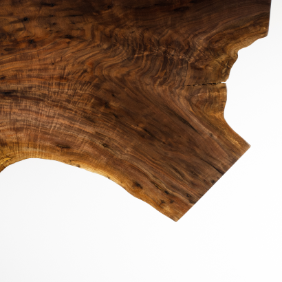 Close-up of a wooden surface with natural grain patterns and a curved edge.