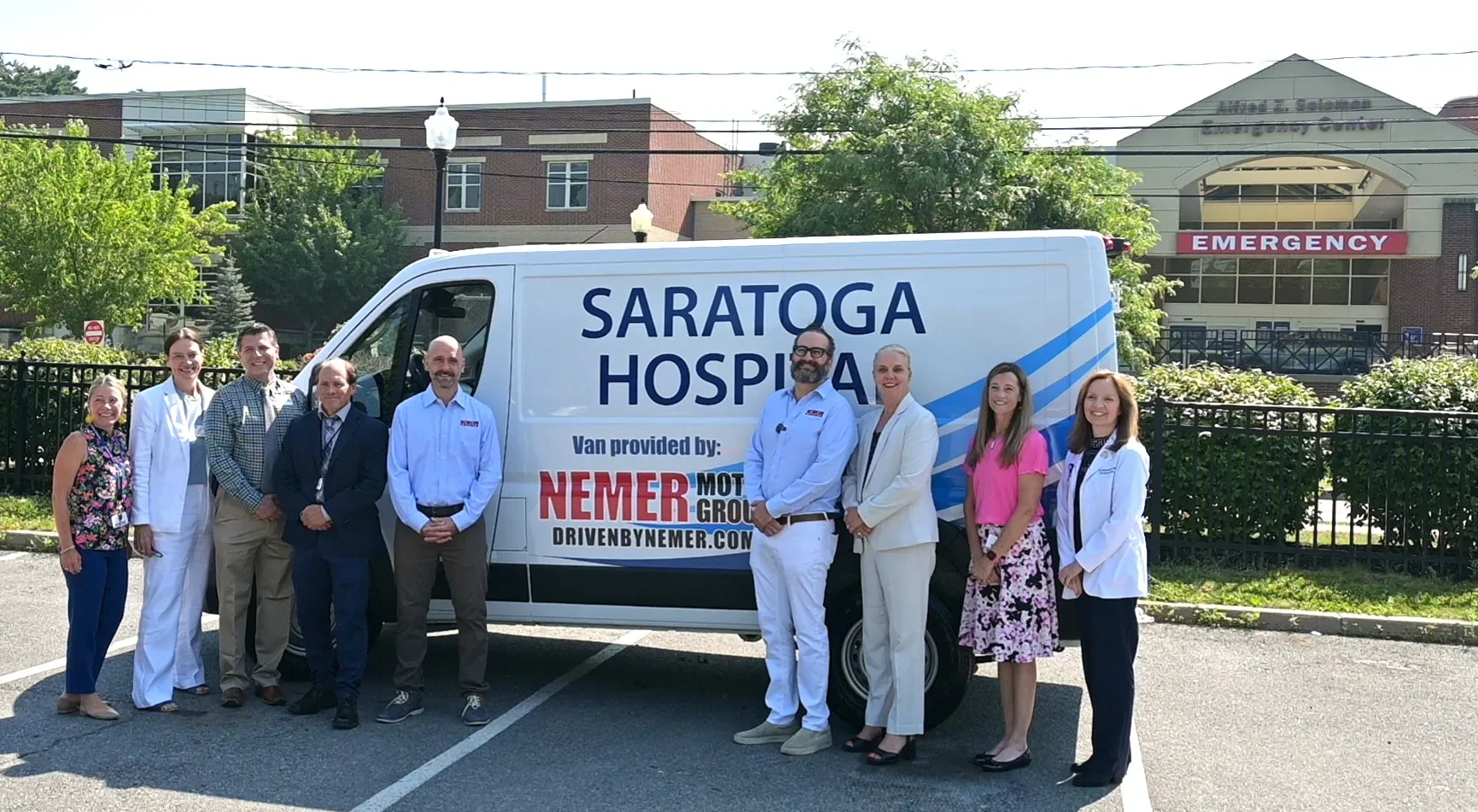 Group of people standing in front of a Saratoga Hospital van outside the hospital building