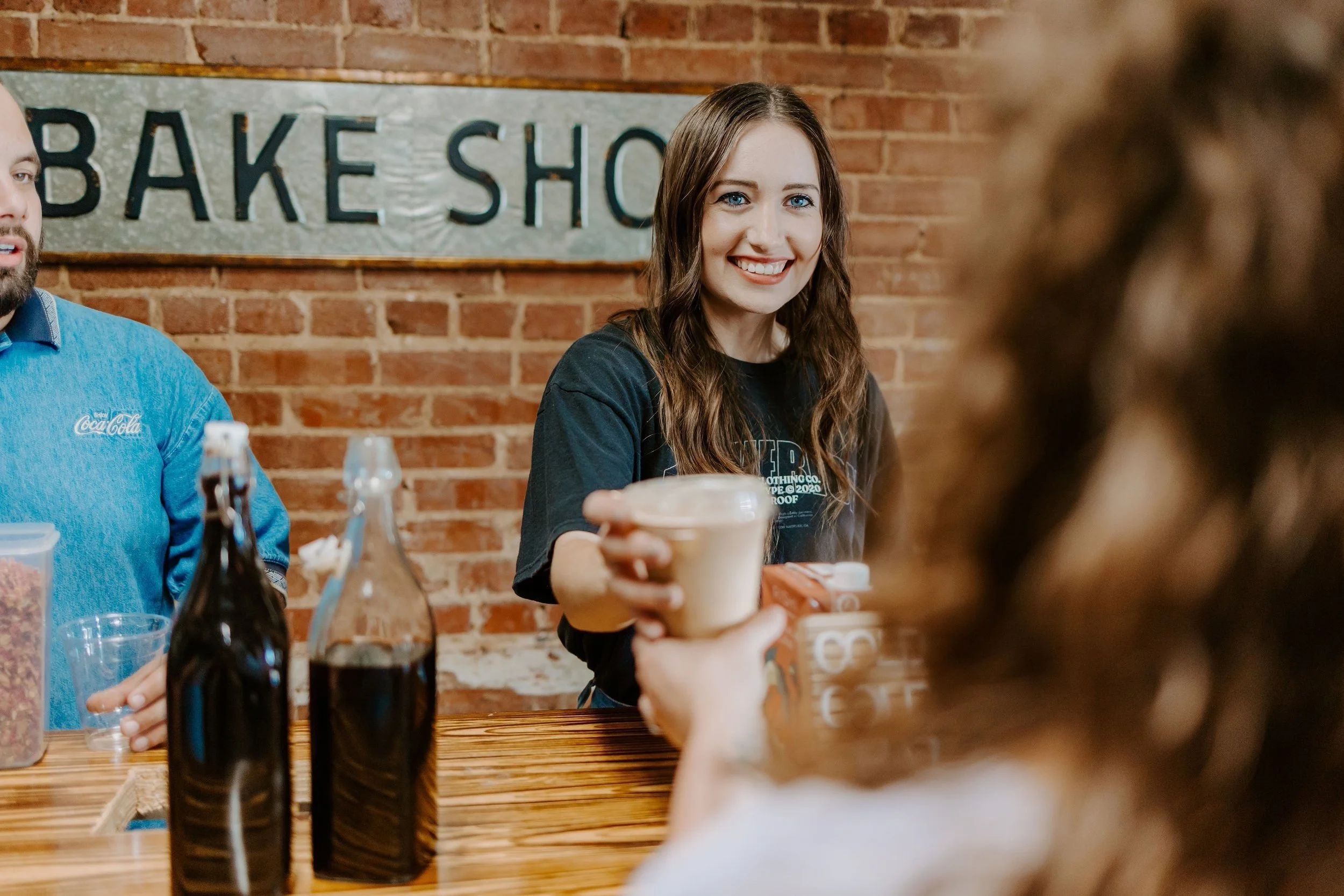 Promise Coffee barista handing a drink to a guest at an event