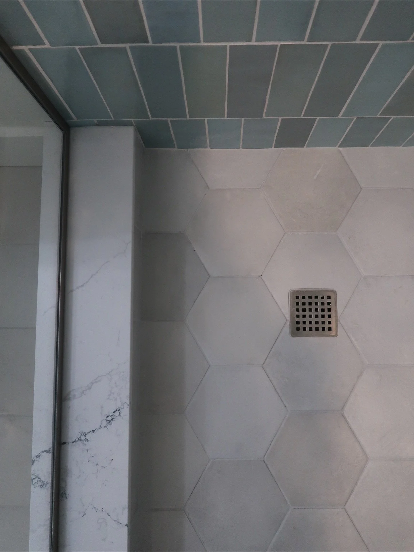 Carrying the same soft blue tones from the laundry room, the basement bathroom at the Wiley residence brings a calm, spa like energy to the home. The mix of matte hex tiles and glossy vertical tile creates just the right balance of texture and tone. 