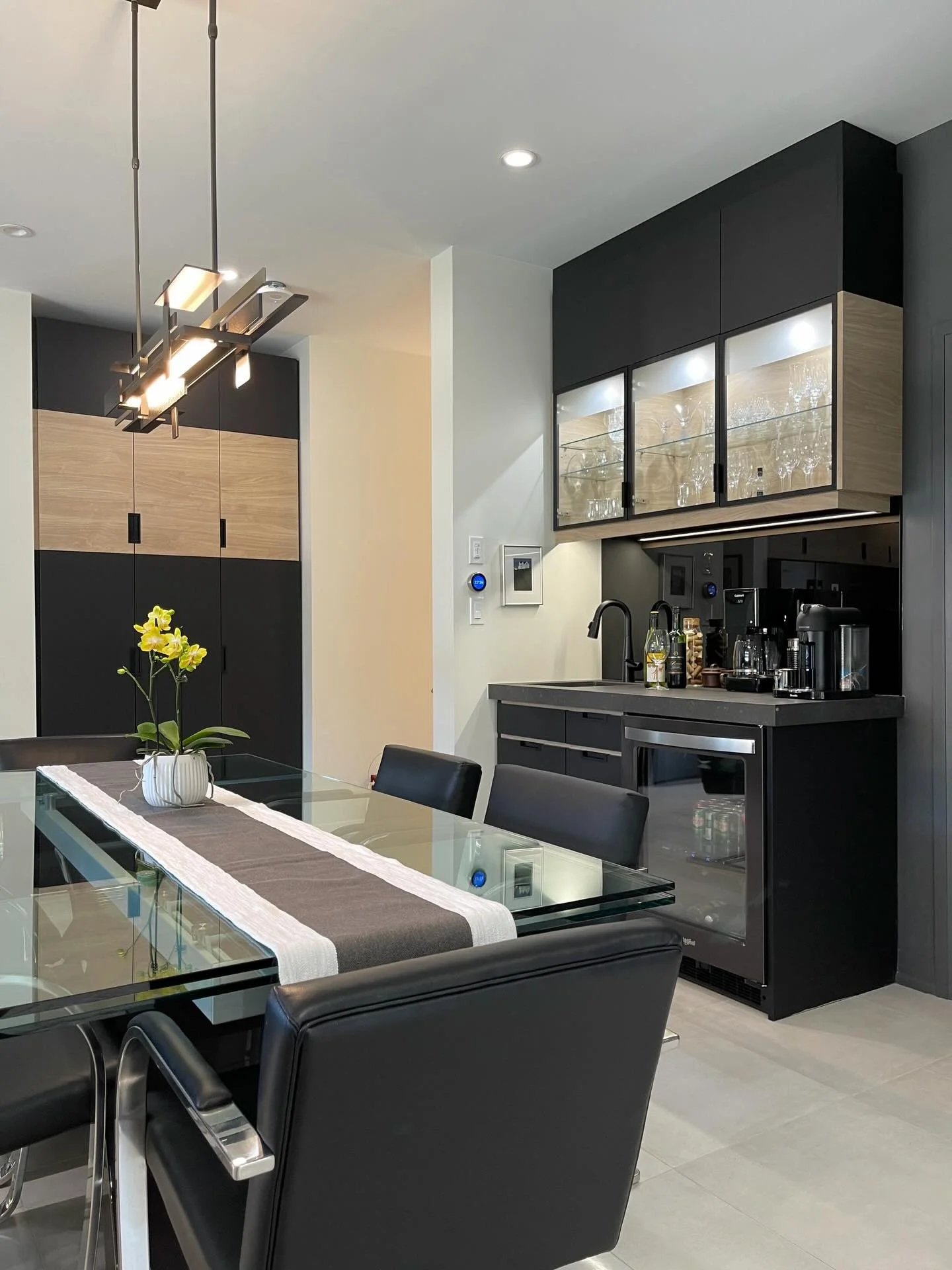 Moving into the dining space of the Richmond Woods condo, we keep the same clean, modern vibe flowing throughout. The pantry and wet bar pick up and continue the horizontal detailing from the kitchen tying everything together. Designed to be function
