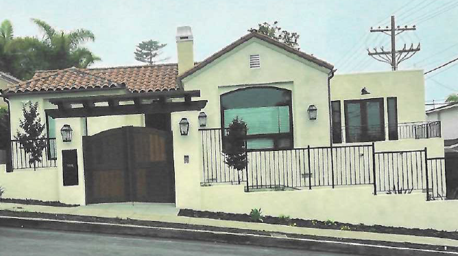 pink apartment building with arched iron details overlooking the Pacific Ocean