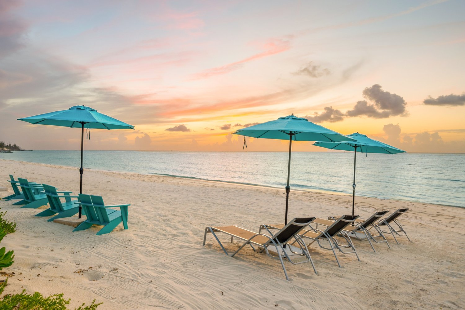 Beach chairs and umbrellas at sunset on the beach at Old Fort Bay, Bahamas