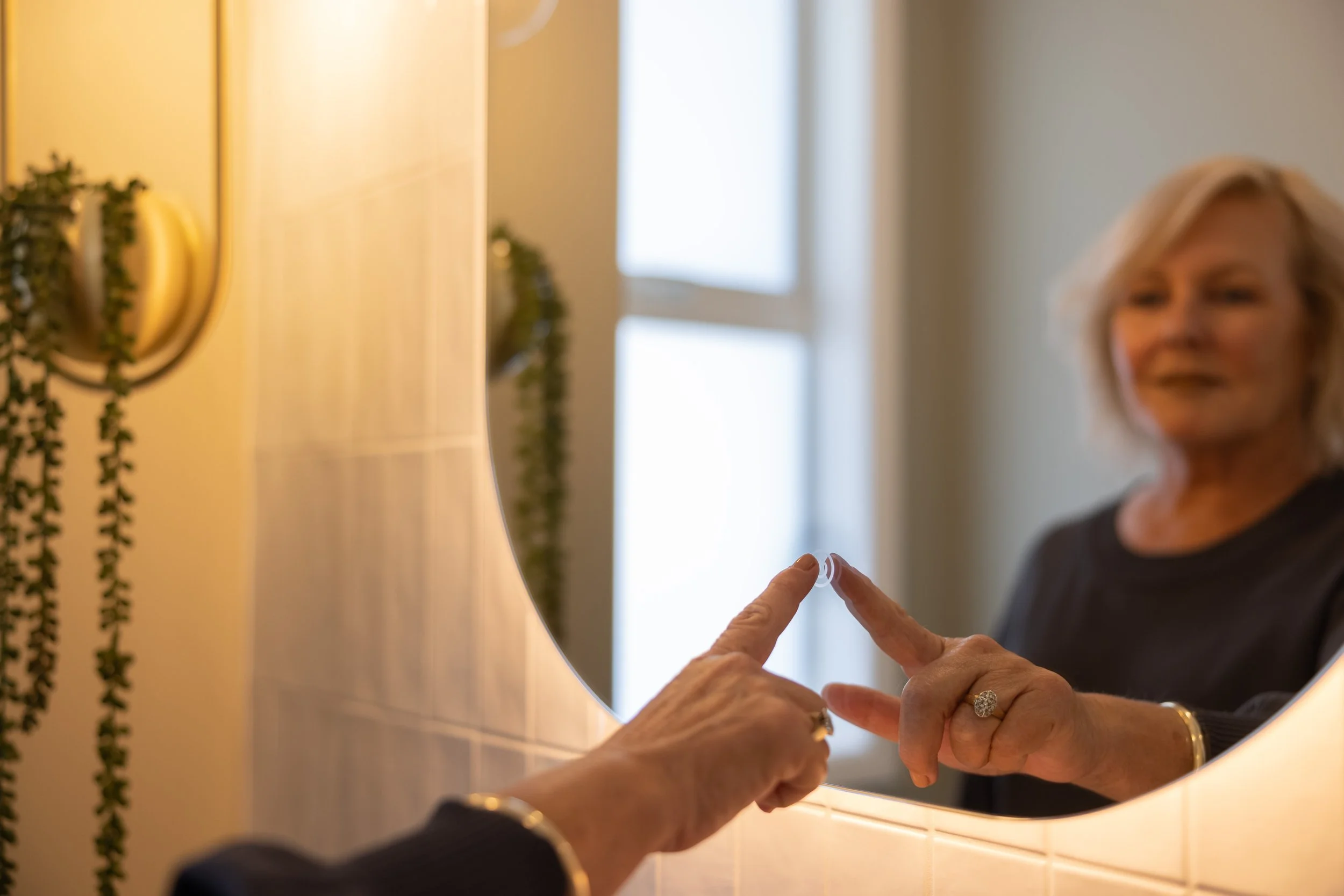 lady turning on LED mirror electrical install by Cablerite