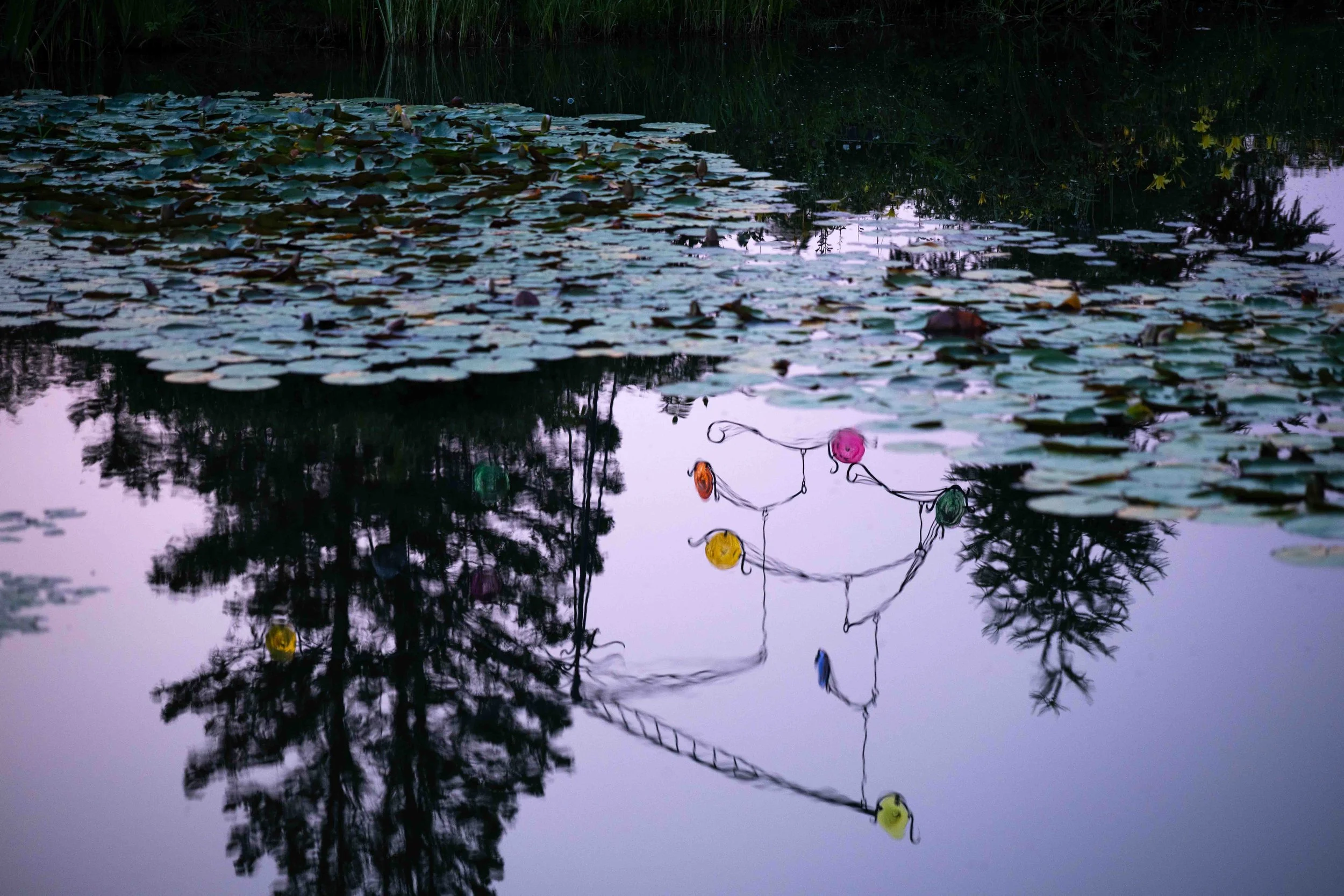 Early morning reflection of a sculpture in a still pond