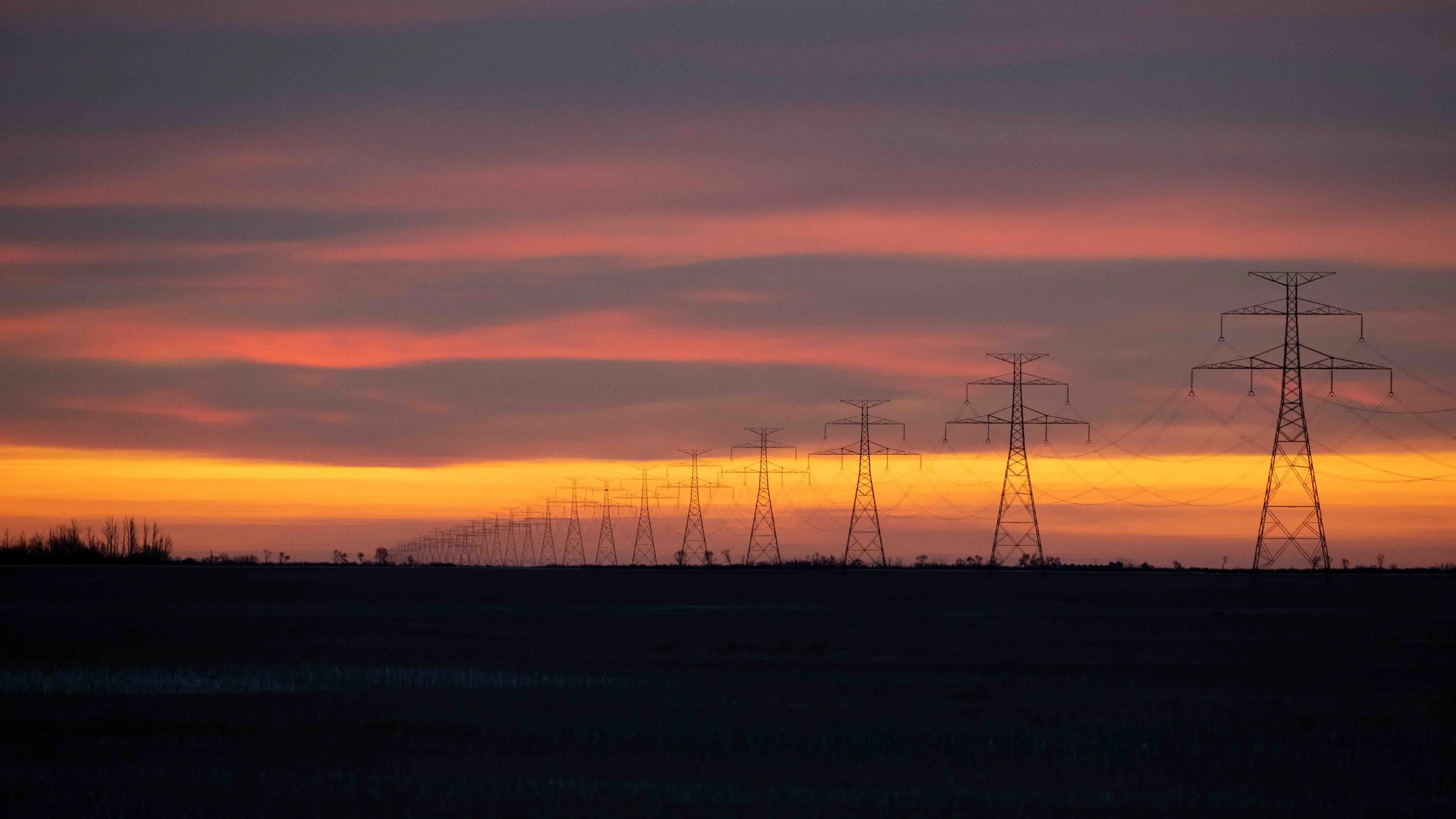 prairie sunrise with power poles in the distance