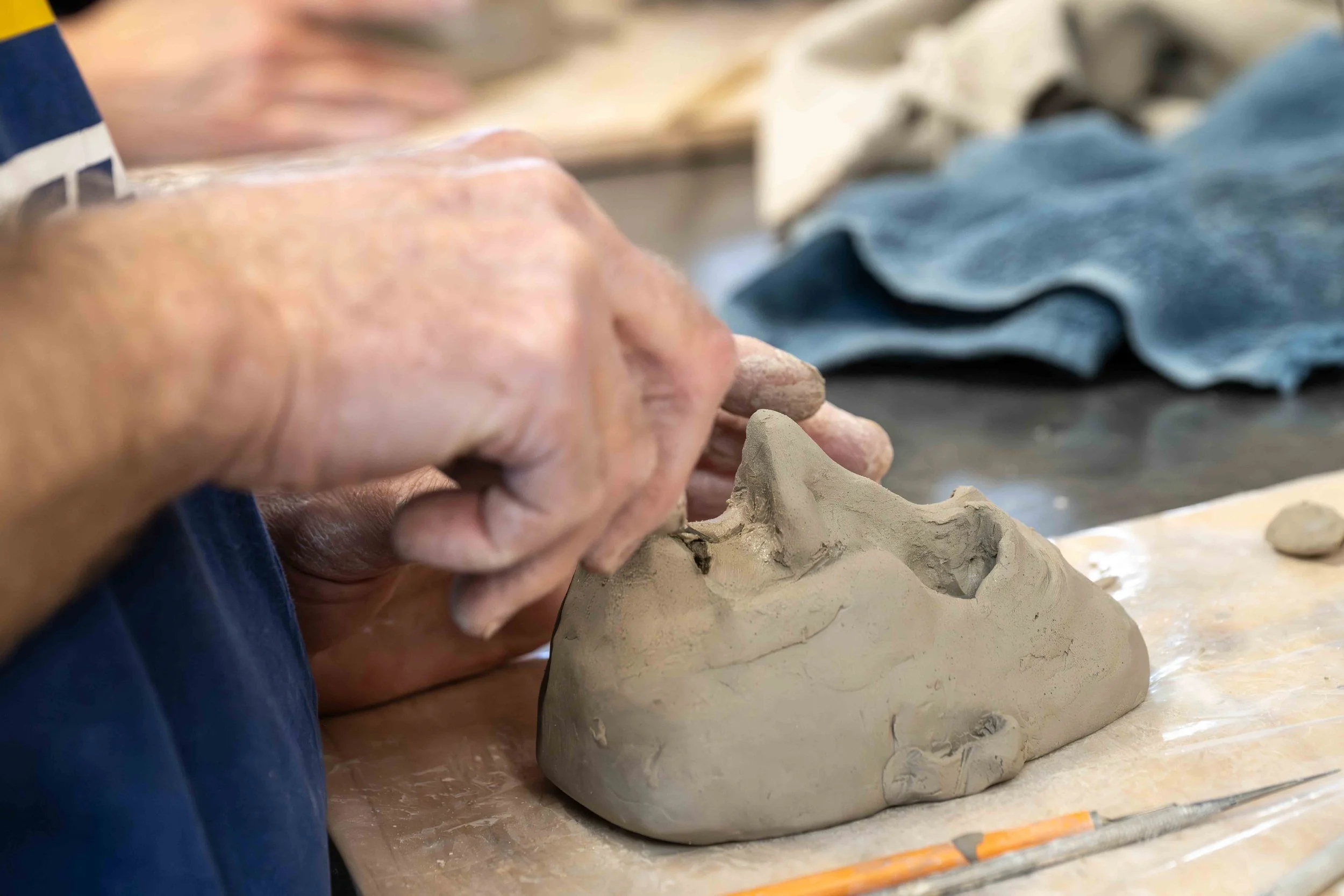 Fashioning a face out of clay to make the puppet's head