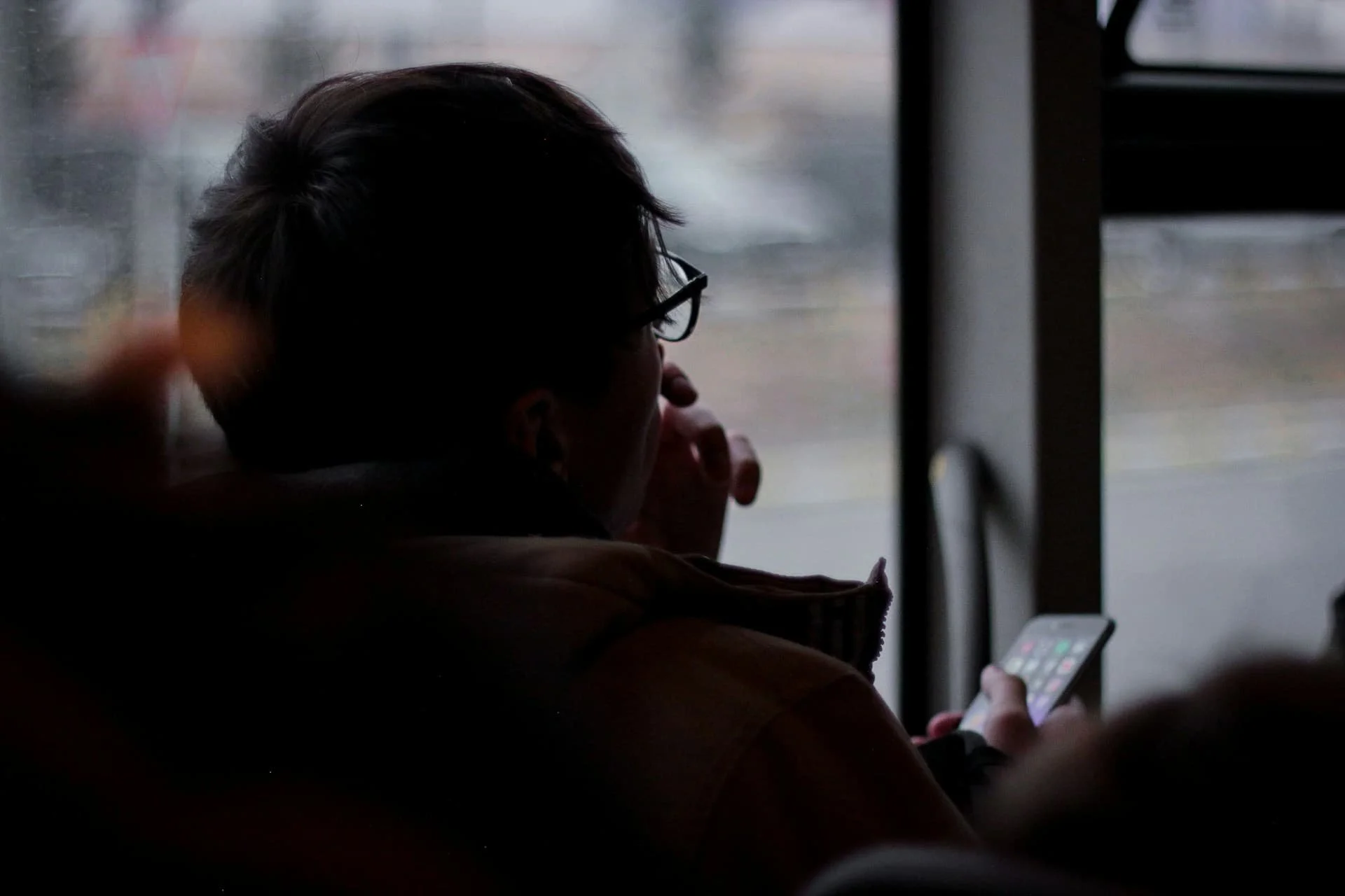 man-holding-phone-sitting-on-chair