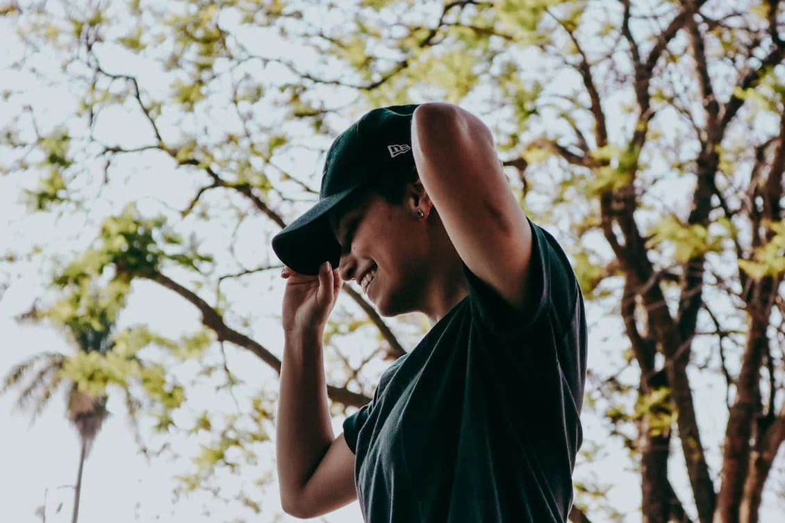 woman-holding-cap-on-head
