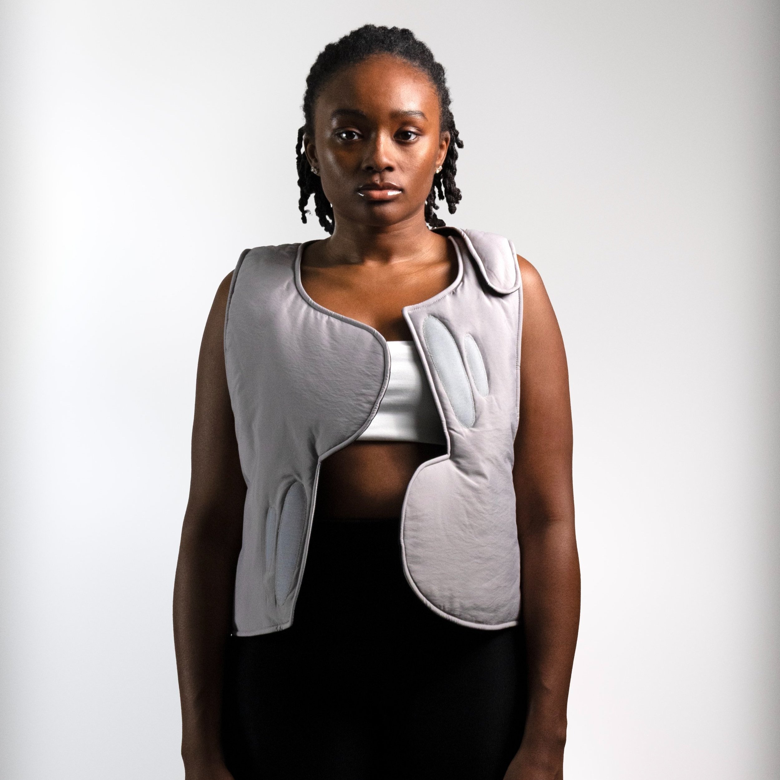 Grey puffer vest with assymetric curve flap closure, overlapping vest, asymmetric vest, asymmetric puffer vest
