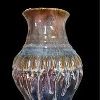 Decorative ceramic vase with a flared top and colorful glaze, featuring textured, dripped patterns.