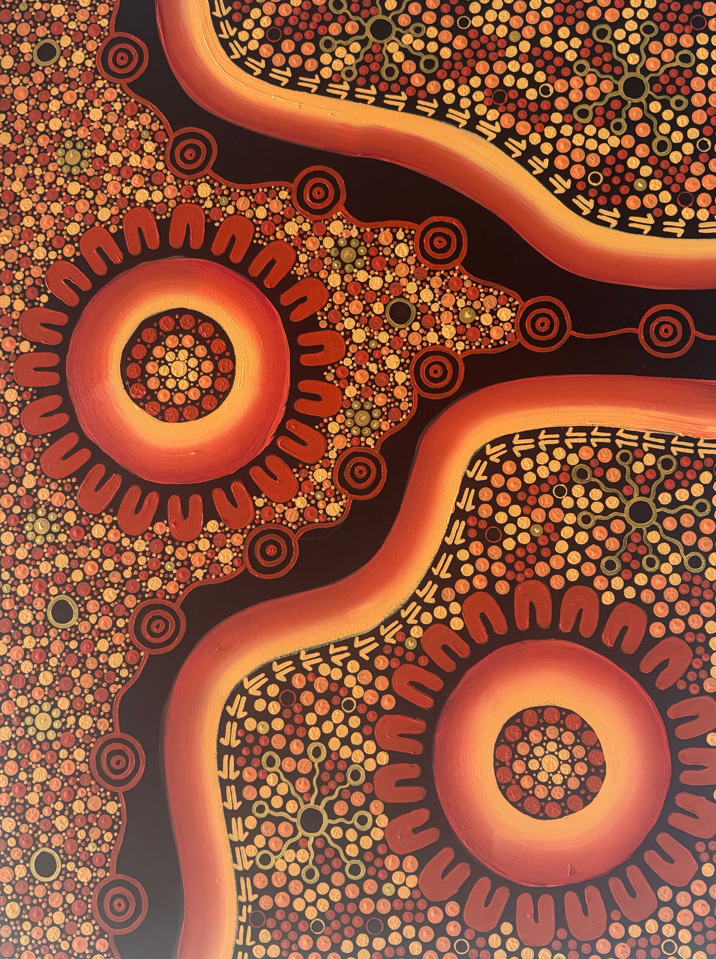 Abstract dot painting with concentric circles and interconnected patterns in shades of orange, red, yellow, and black.
