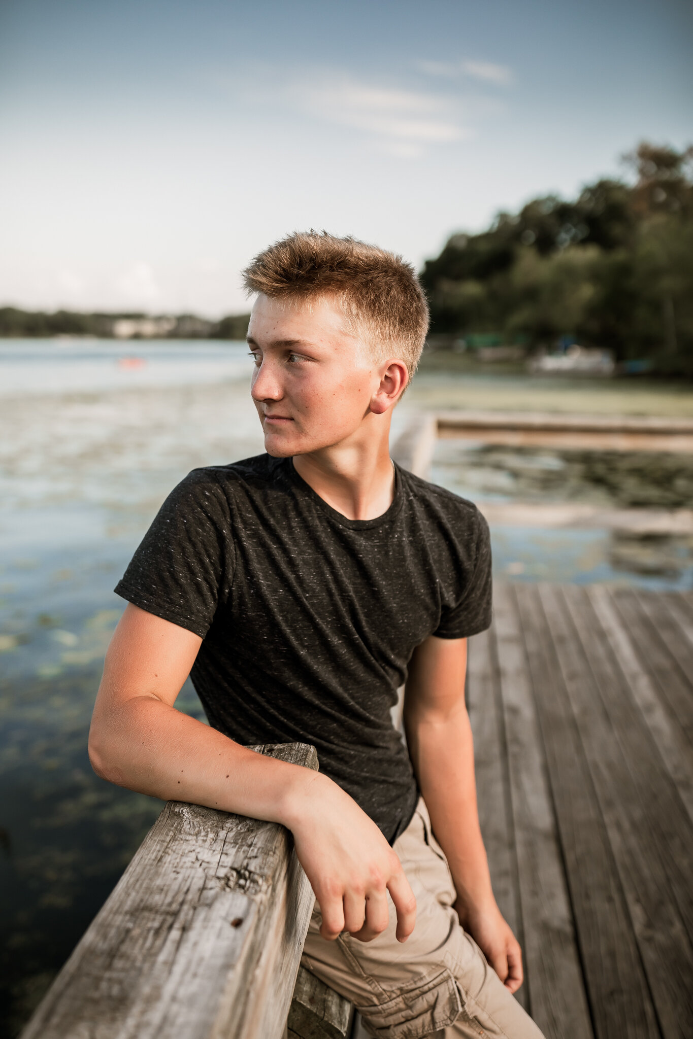 A high school senior sitting on the fishing pier at West Medicine Lake Park in Plymouth, MN | Wayzata High School Senior Photographer