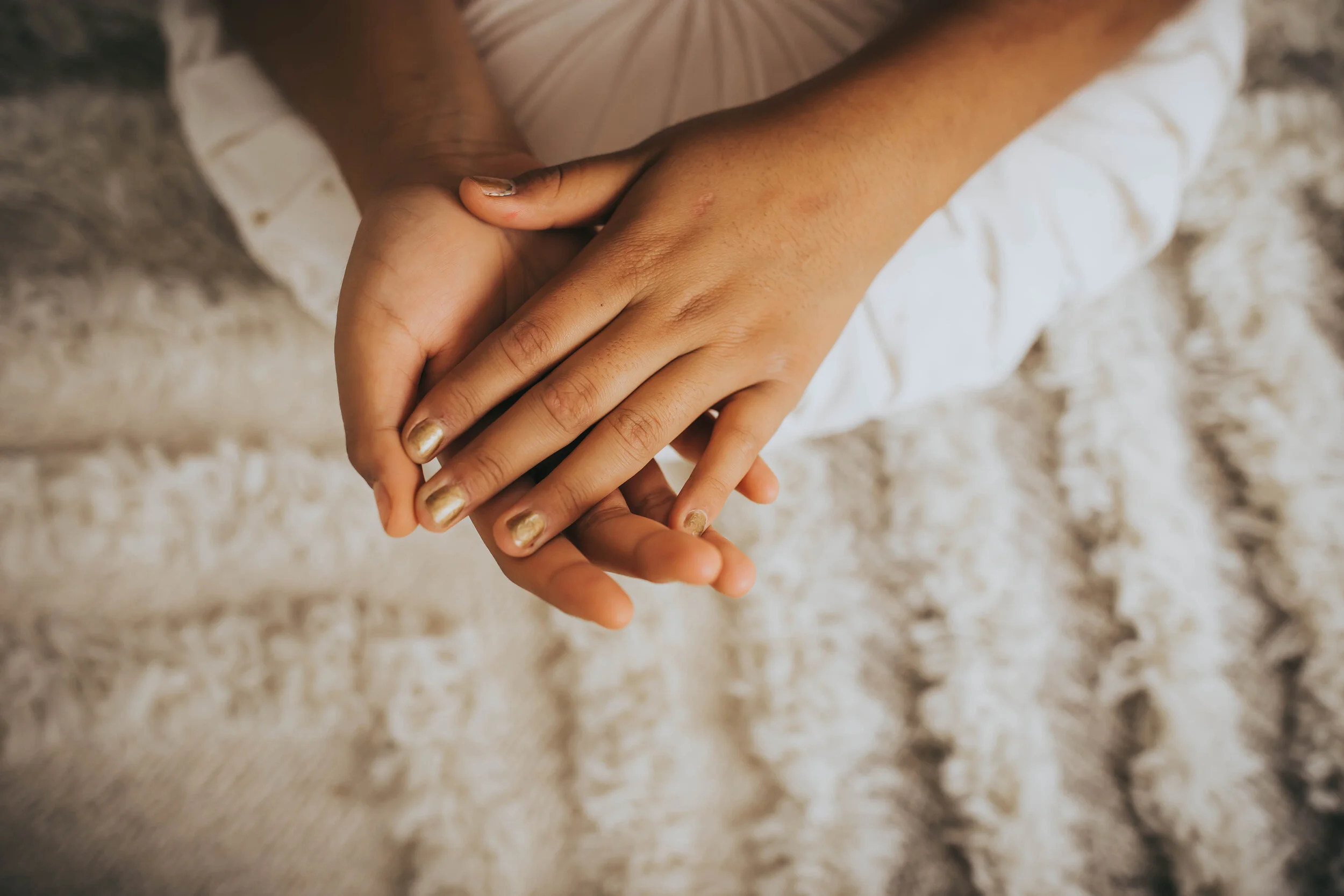 An image of a girl’s hands hands with gold nail polish | AMG Photography