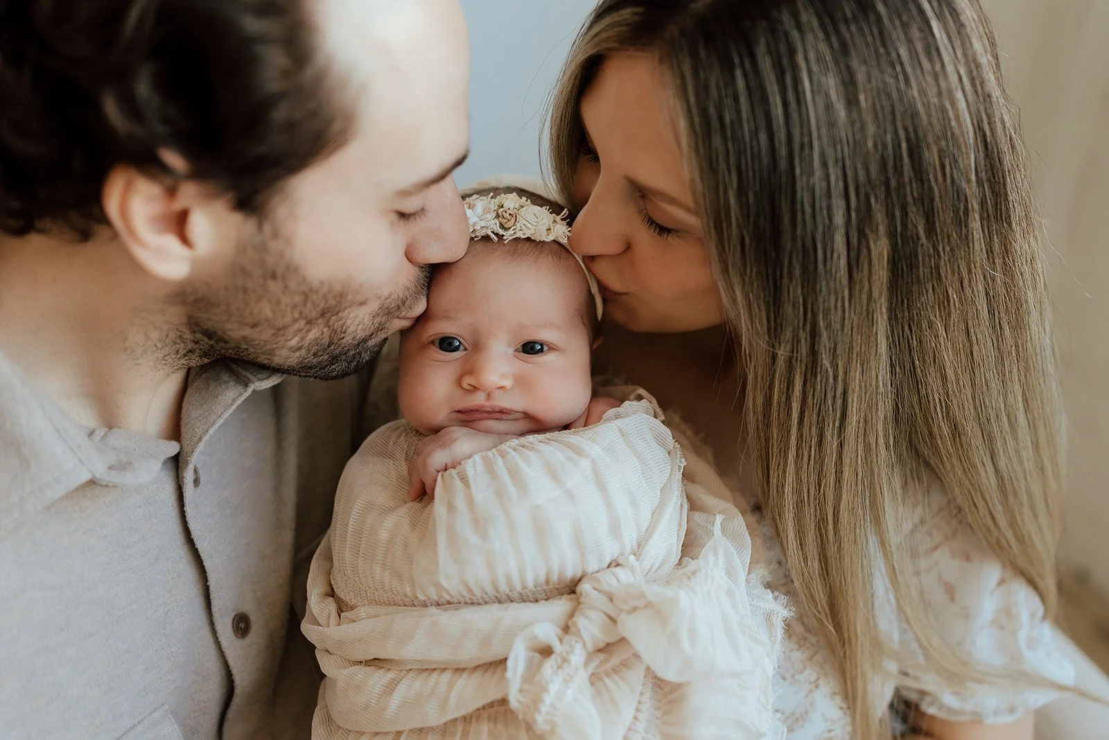 new mom and dad holding a newborn baby girl