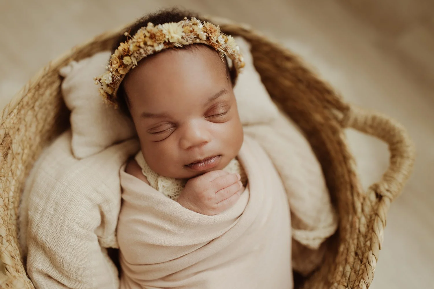 A baby girl sleeps soundly in a woven basket.