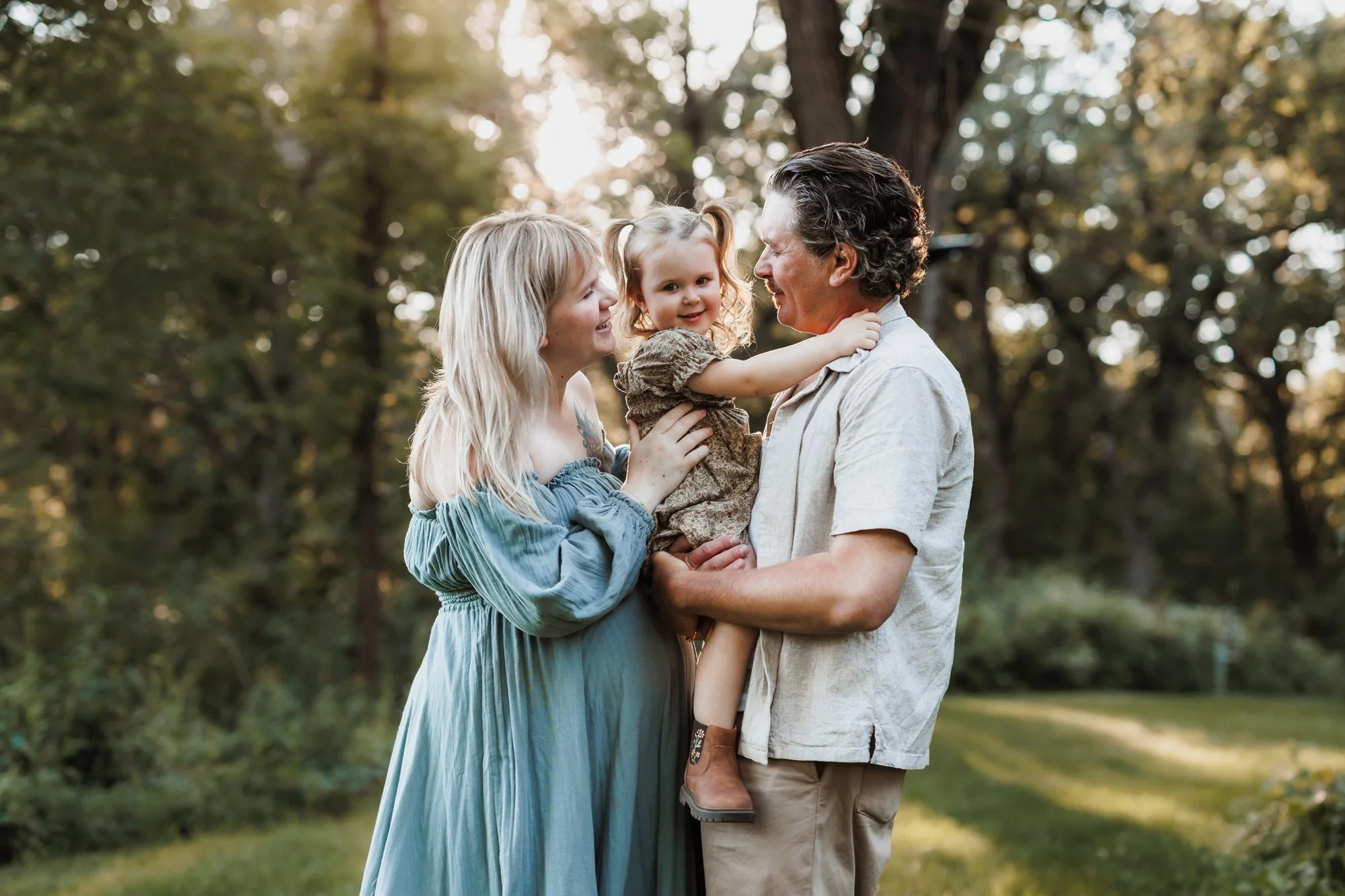 family of three is enjoying family pictures at Burwell Park in Minnetonka, MN